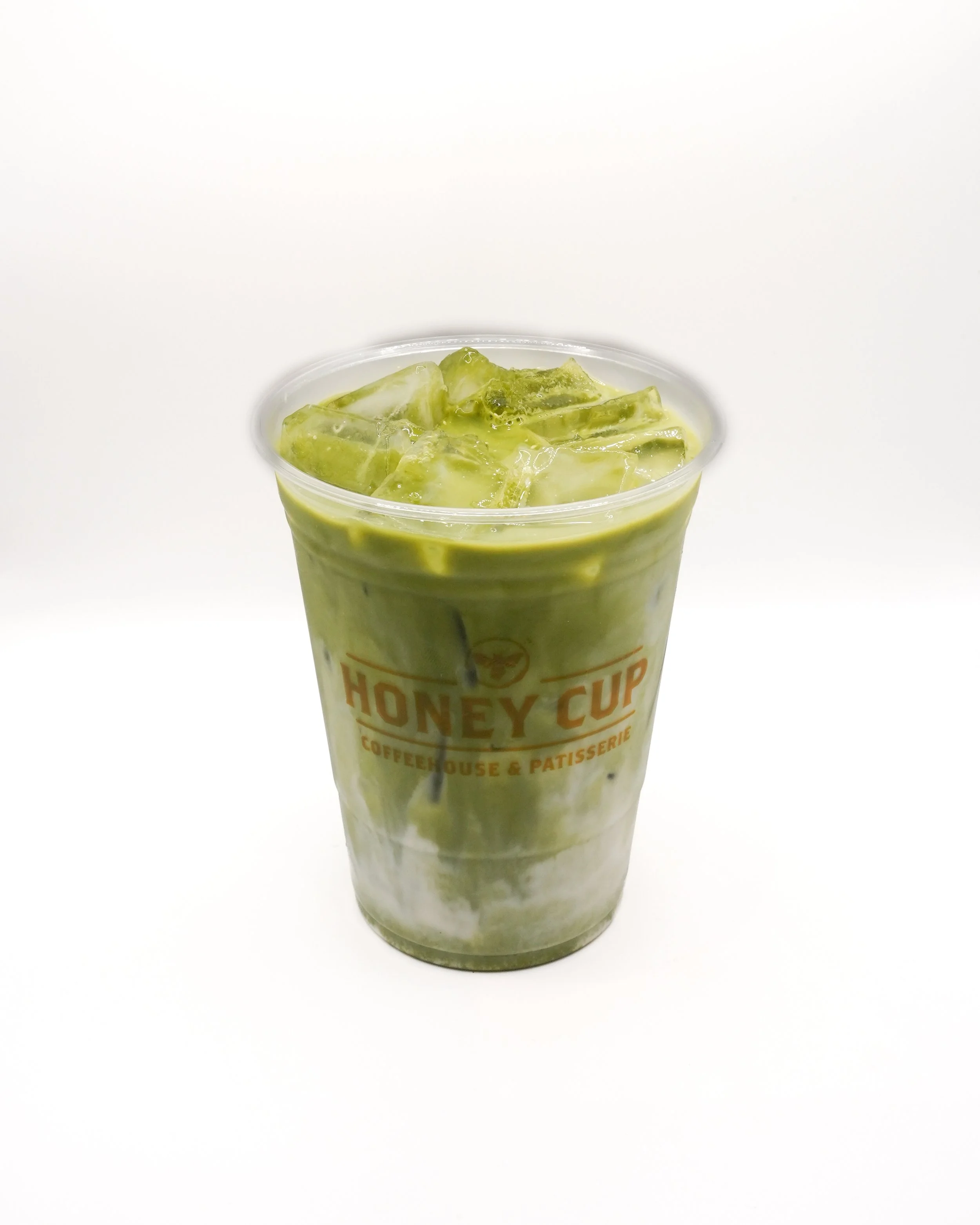 Iced matcha latte from Honey Cup Coffeehouse & Patisserie in a clear plastic cup with layered green tea and milk best matcha near me