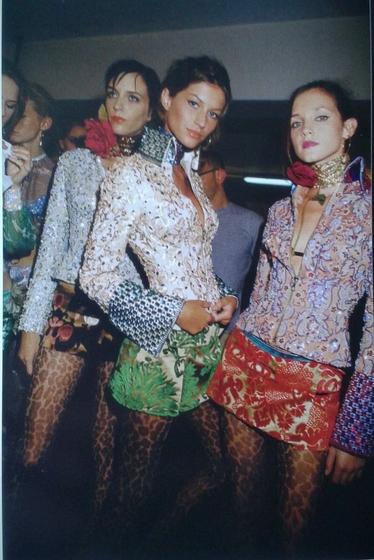 Group of women dressed in eclectic, colorful fashion with patterns and textures, standing together indoors.