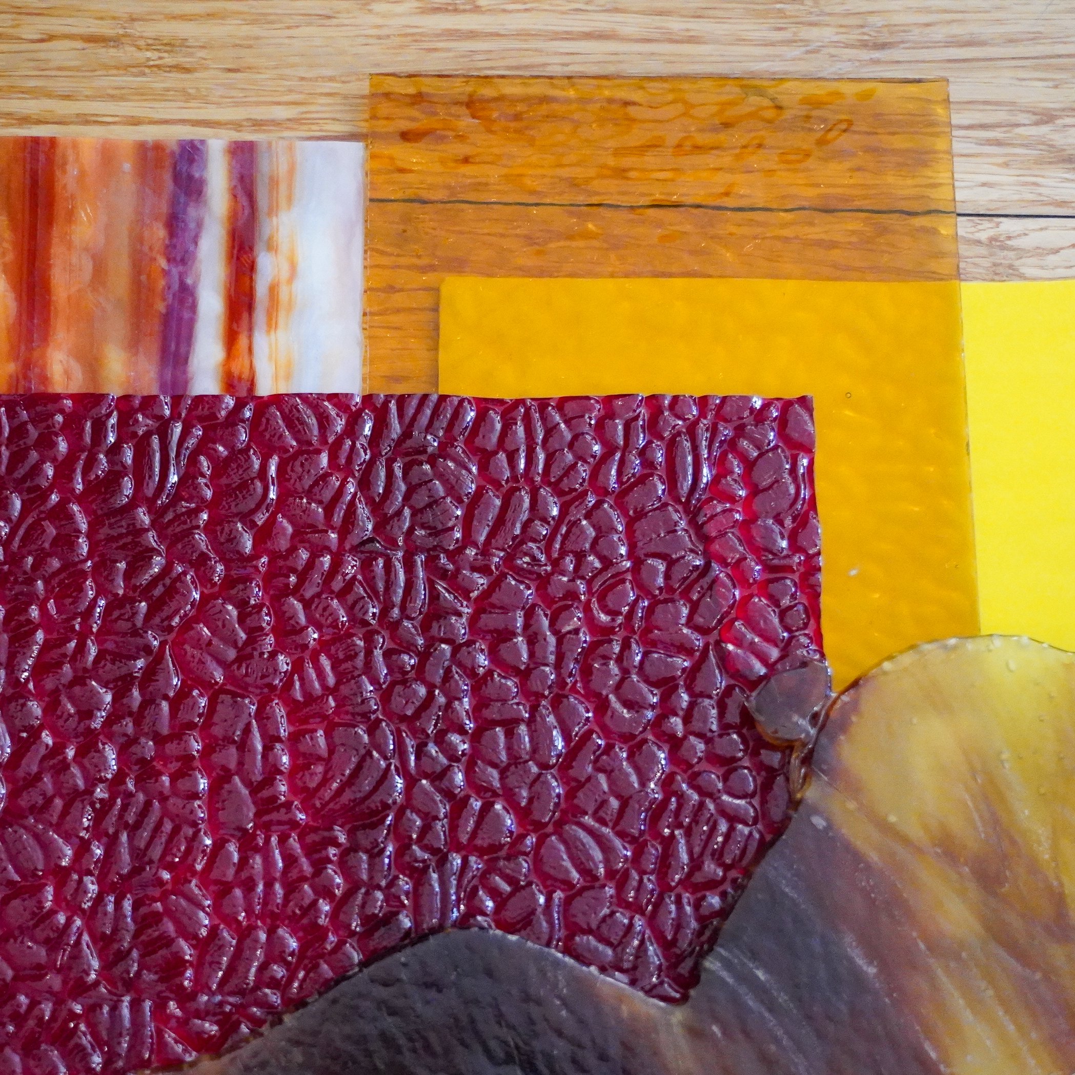Close-up of various colorful textured and patterned glass pieces.
