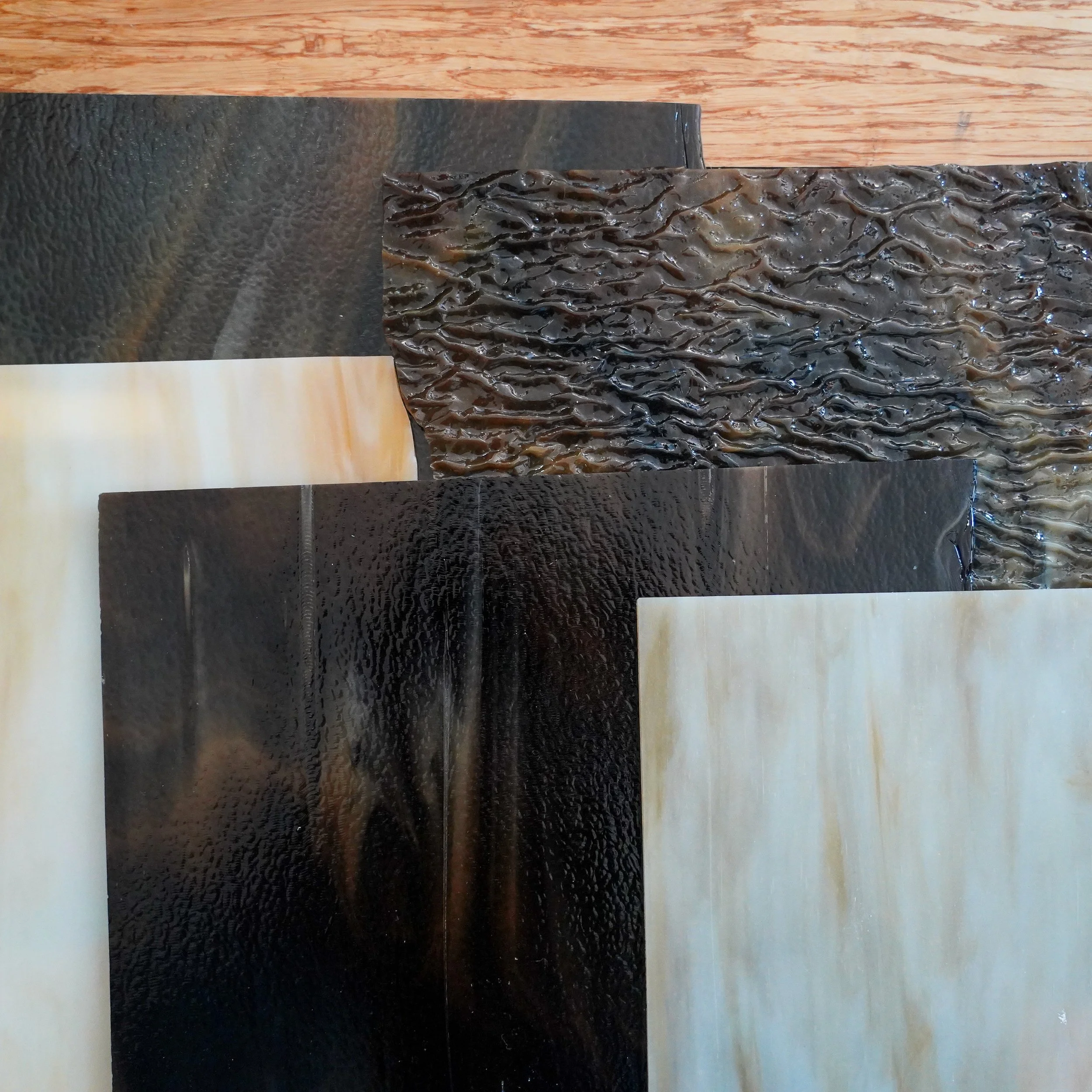 Arrangement of various textured panels in black, beige, and brown with different surface finishes.