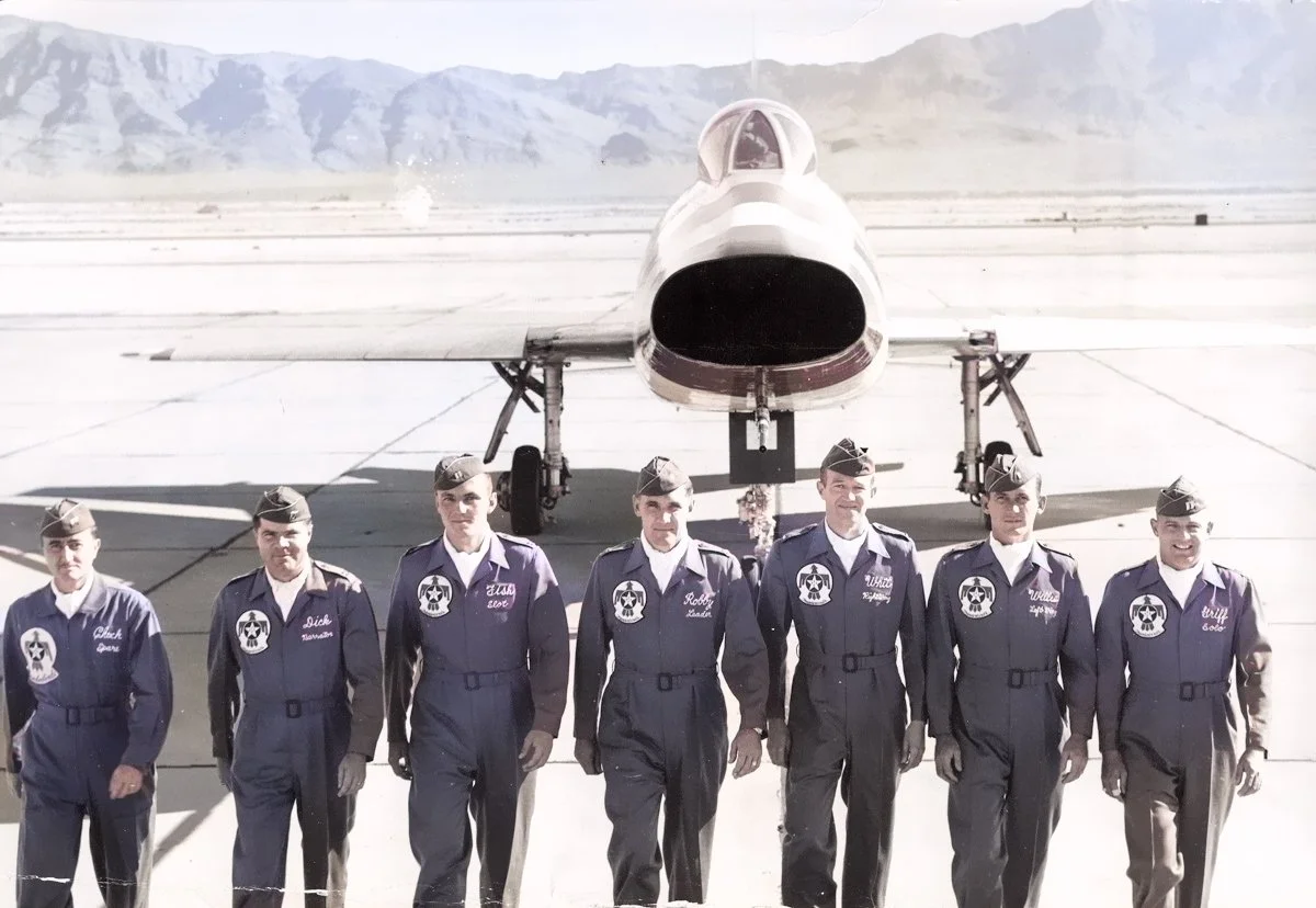 Seven U.S. Air Force Thunderbird pilots in flight suits walk toward the camera in front of an F-100 Super Sabre jet on the runway at Nellis Air Force Base in the late 1950s. Capt. Charles “Chuck” Salmon, nicknamed “Fish,” stands third from the left.