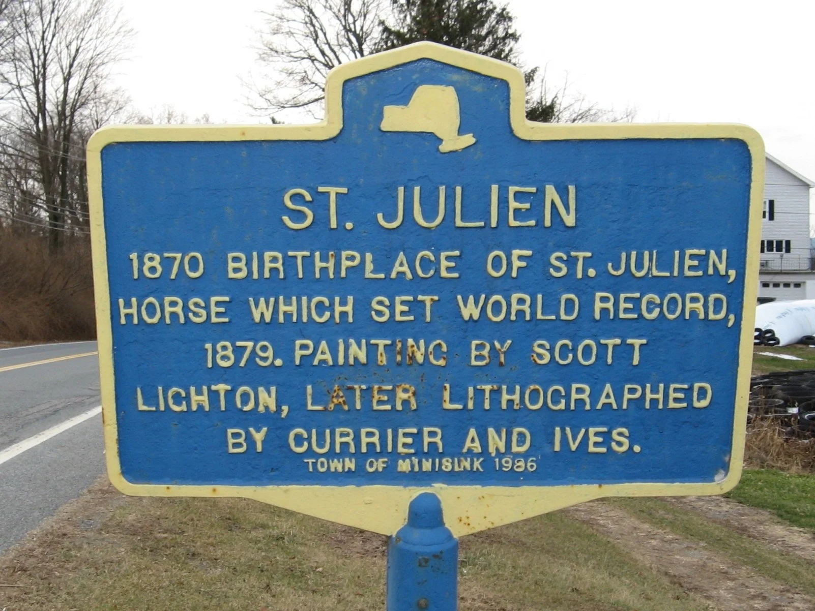 Blue and yellow roadside historical marker reading “St. Julien,” marking the birthplace of the champion trotting horse in Westtown, New York.