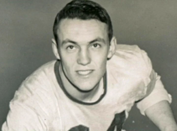 Black-and-white photo of a young Chuck Salmon in a football jersey during his college years at Williams College in the early 1950s.