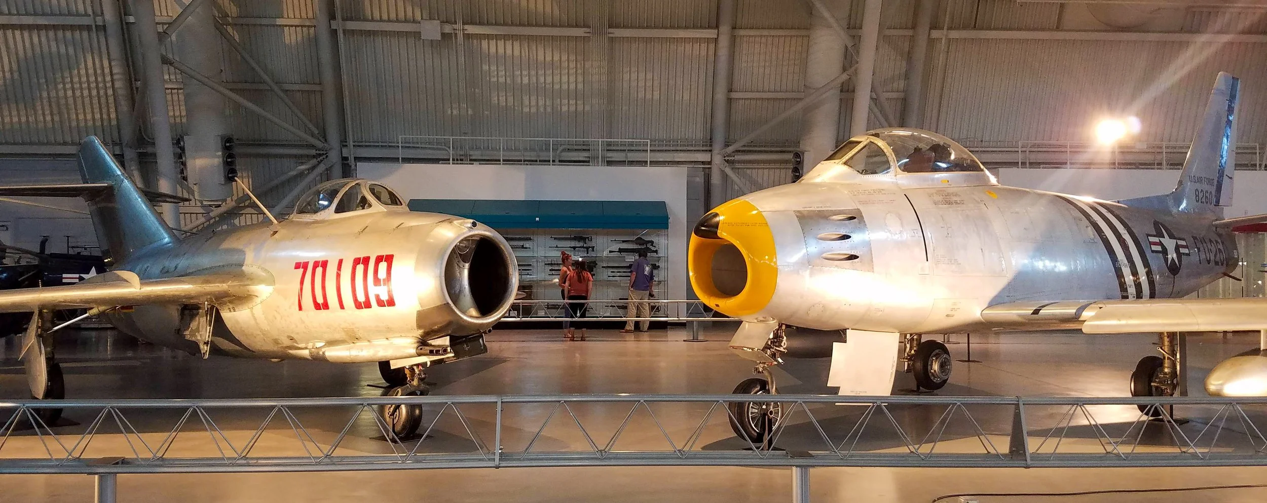 A Soviet MiG-15 and an American F-86 Sabrejet displayed side by side at the Smithsonian National Air and Space Museum’s Udvar-Hazy Center, rival fighter jets that frequently fought each other during the Korean War.