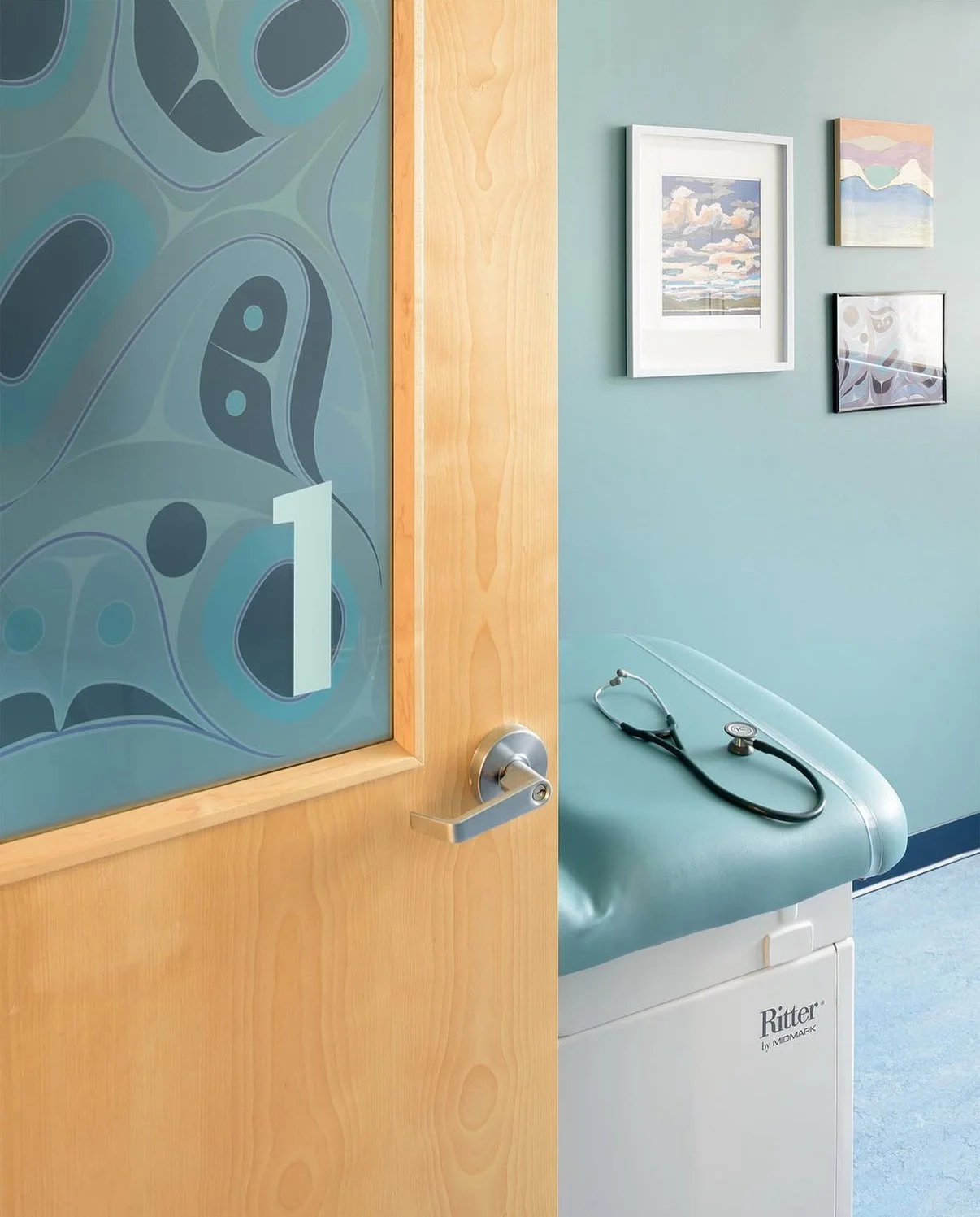 A doctor's office in teal blue showcasing indigenous art, patient centred design. Interior Design for clinics and business serving the greater Victoria Area in BC