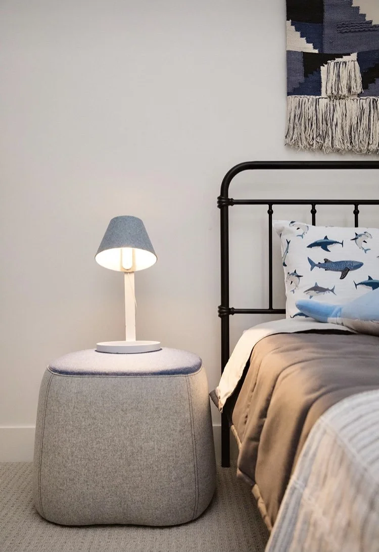 A child's bedroom in a nautical theme showcasing a Pablo light on a Haworth Pouf in heather grey and faded blue. Interior Design Services for homes in Victoria BC