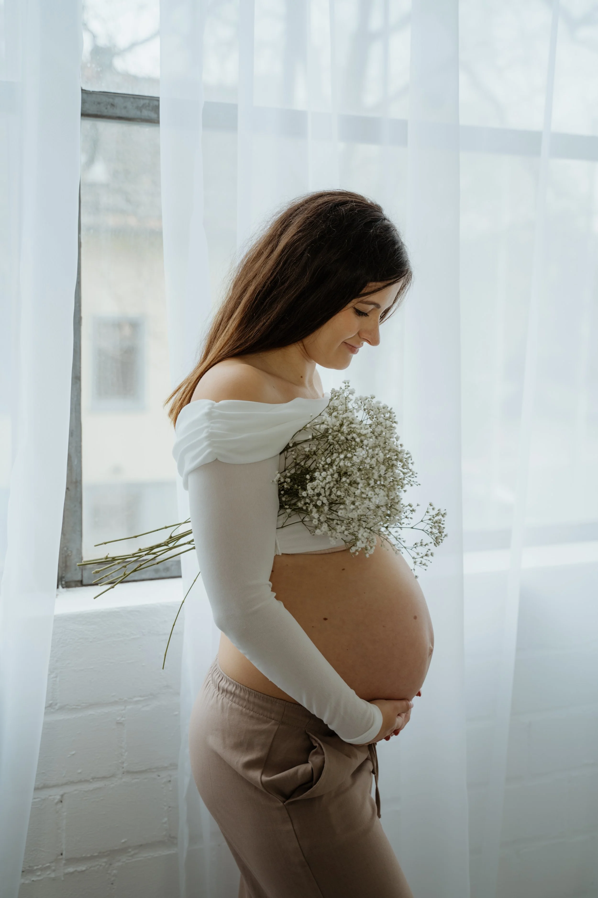 Schwangere Frau beim Babybauch-Shooting im Studio in Köln