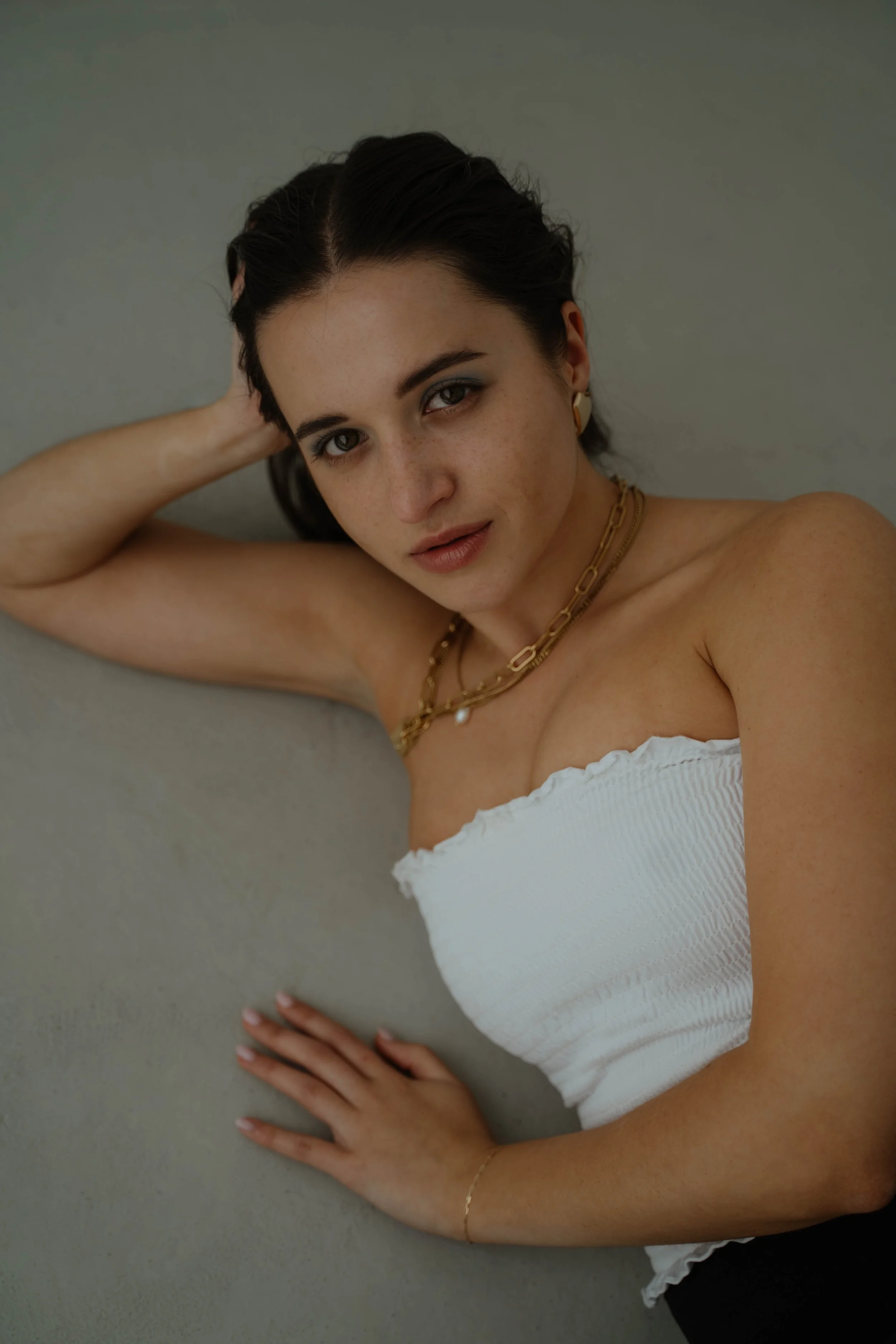 Model im Fotostudio mit goldener Kette für eine Schmuckkampagne.