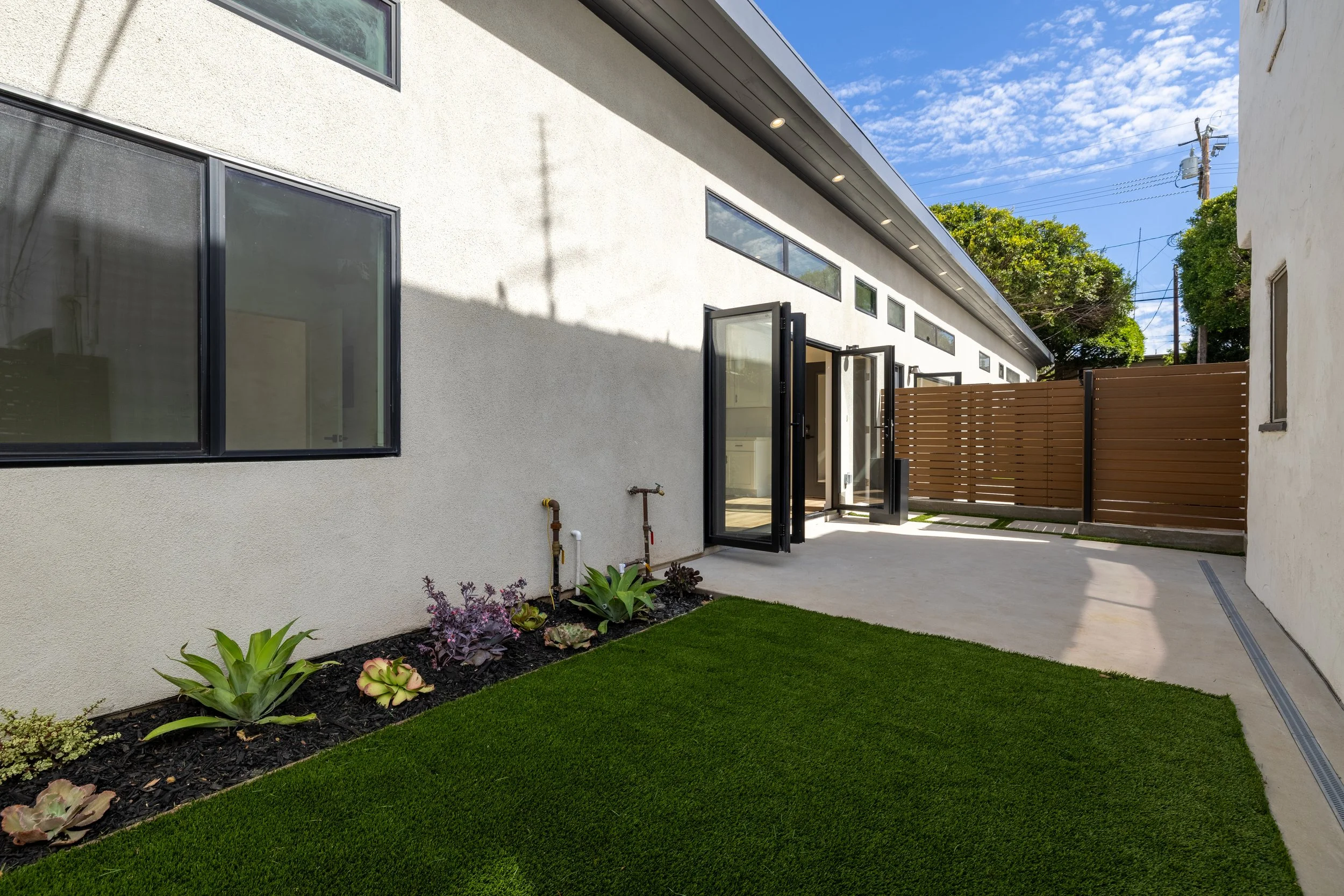 Backyard patio area of a newly renovated modern house in Southern California. Housing development services by Casitas Development