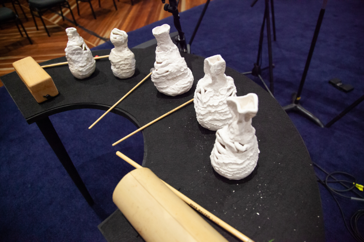Ceramic sculptures on table with percussion beaters