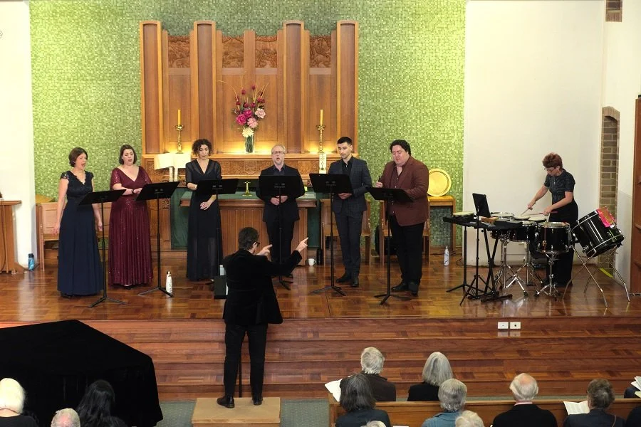 Man directing choir and percussionist