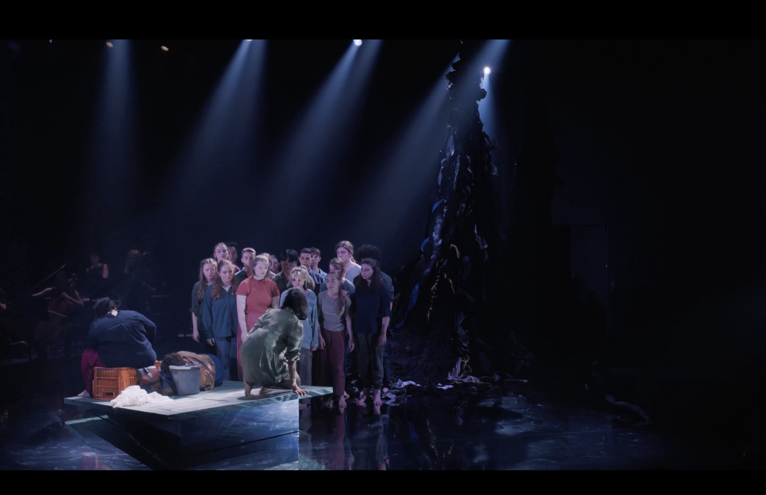 Crowd on stage with dim lighting and spotlights