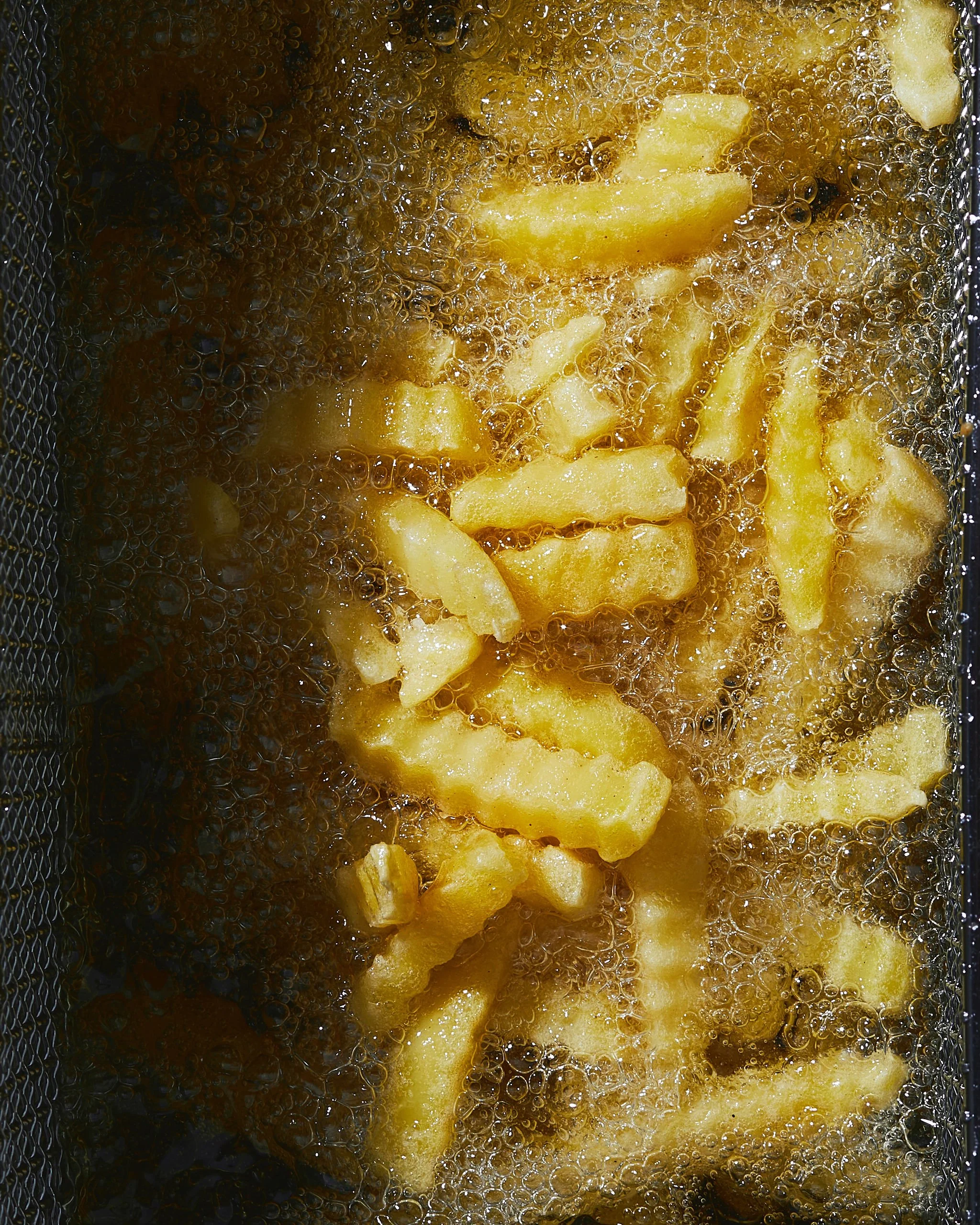 French fries frying in hot oil.