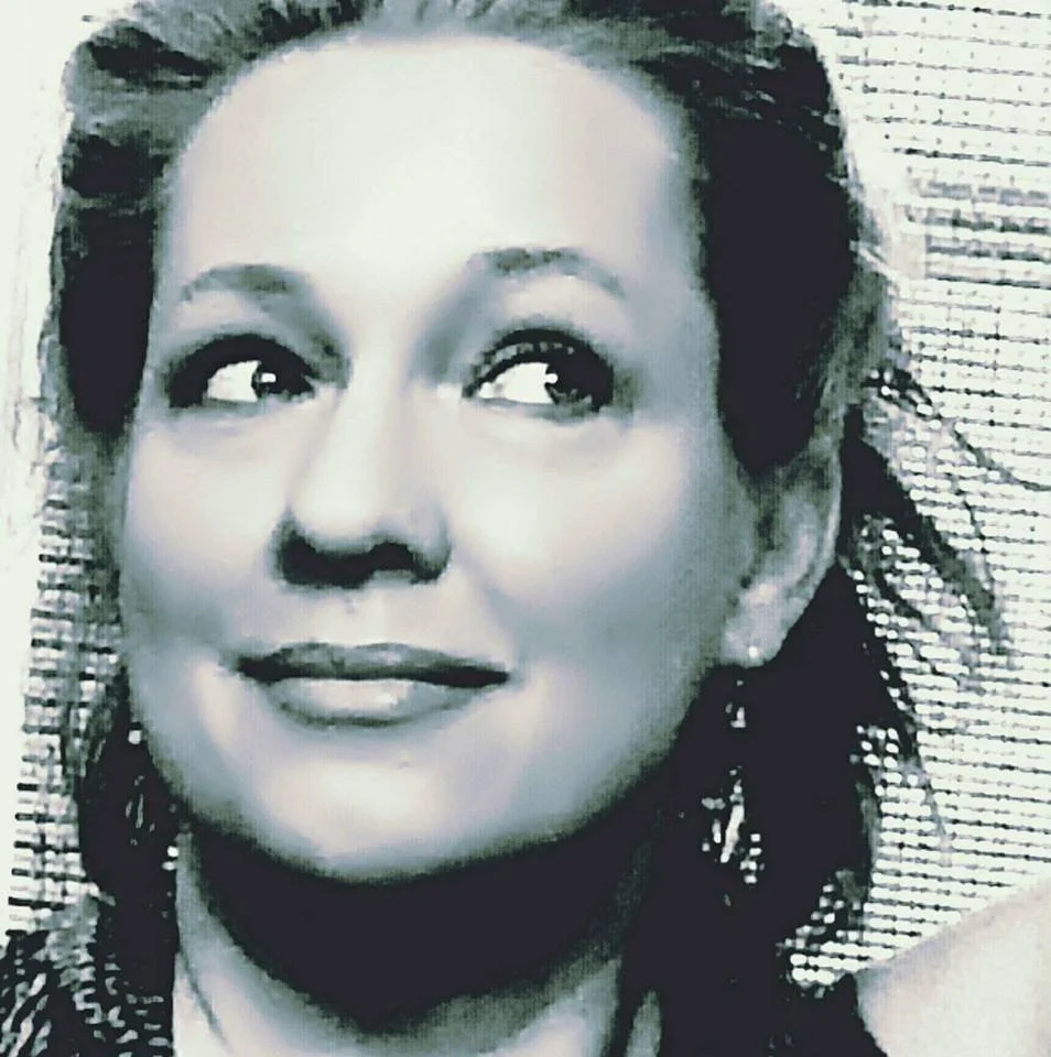 Black and white portrait of a woman with styled hair looking up and to the left.