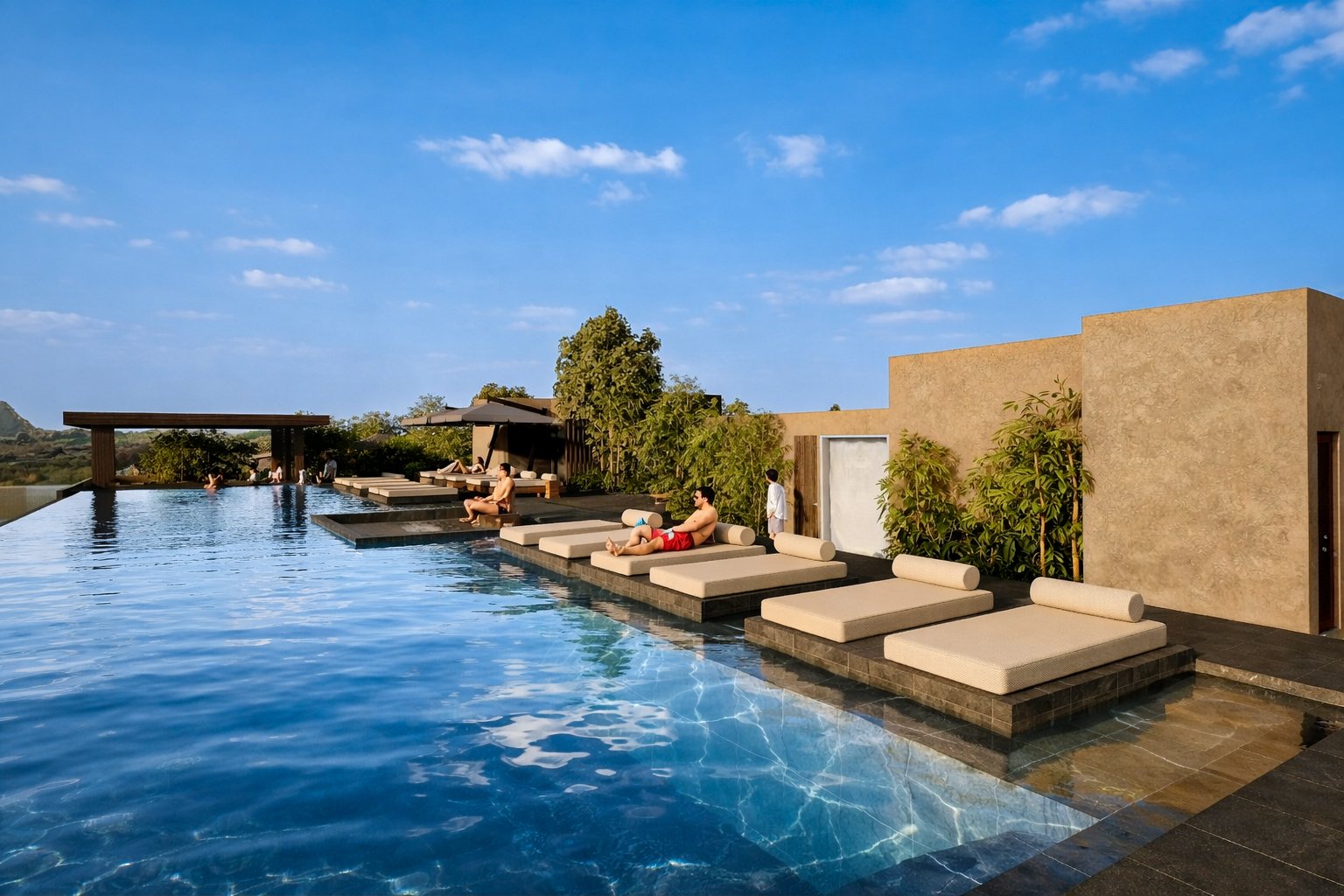 Luxury rooftop infinity pool with floating loungers and people relaxing, surrounded by modern architecture and greenery, under a clear blue sky.