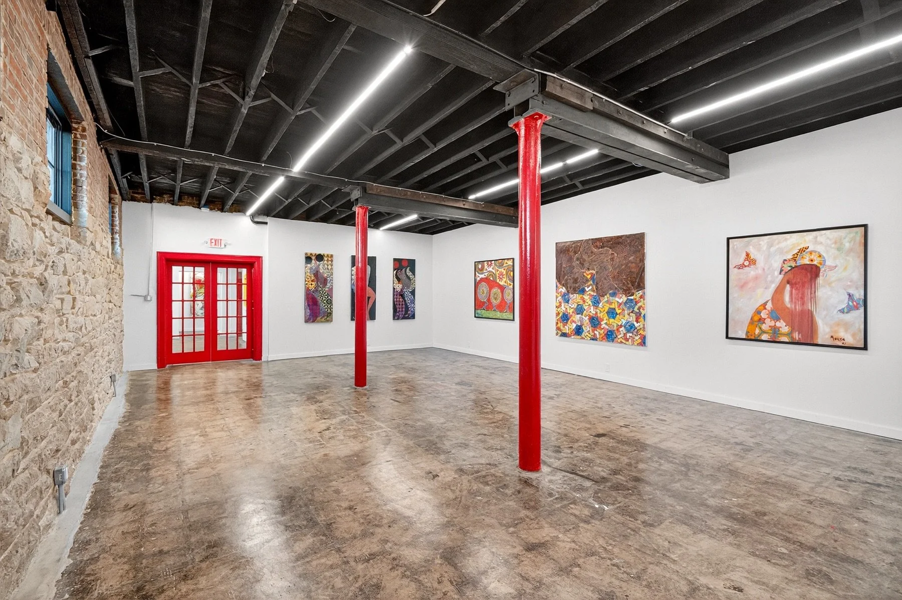 Gallery view with red door and artworks for The Architecture of Memory by Nabil Mousa