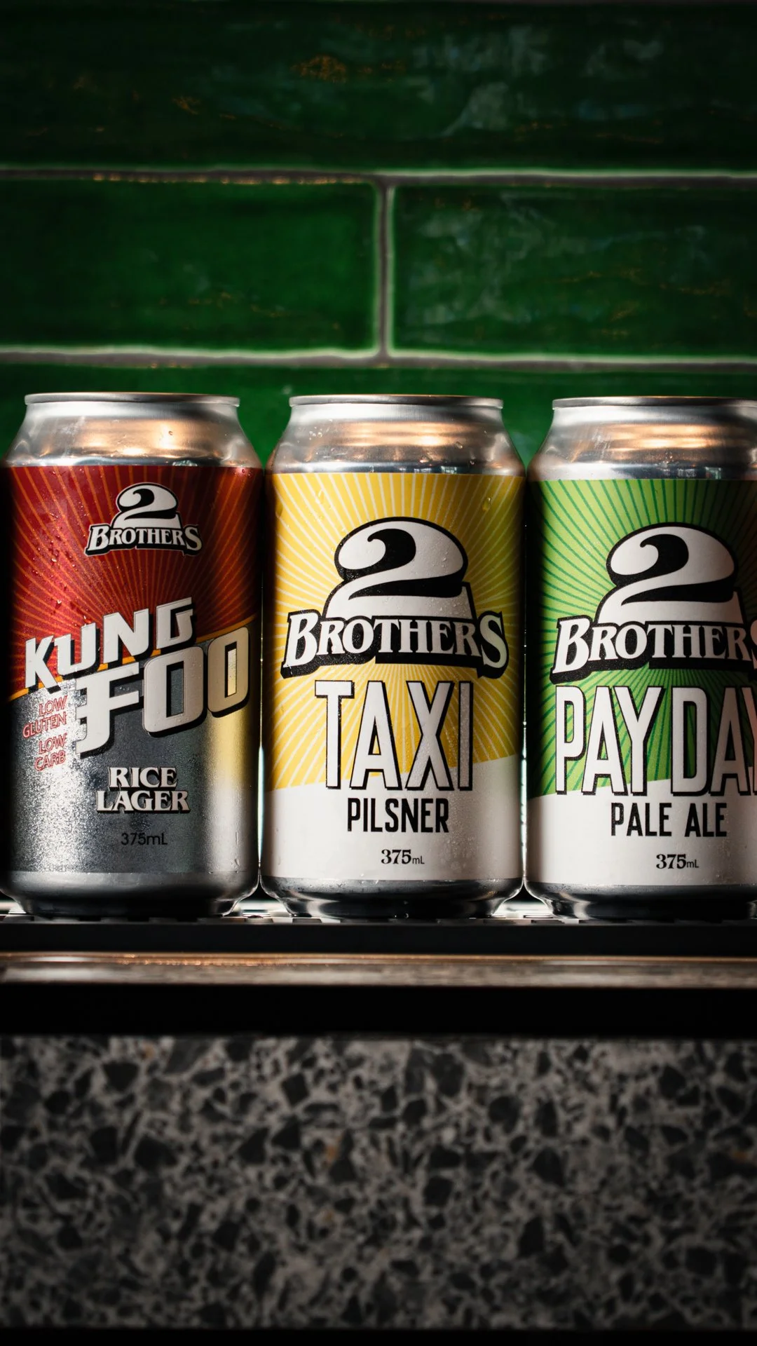 A row of three 2 Brothers Brewery takeaway beer cans.