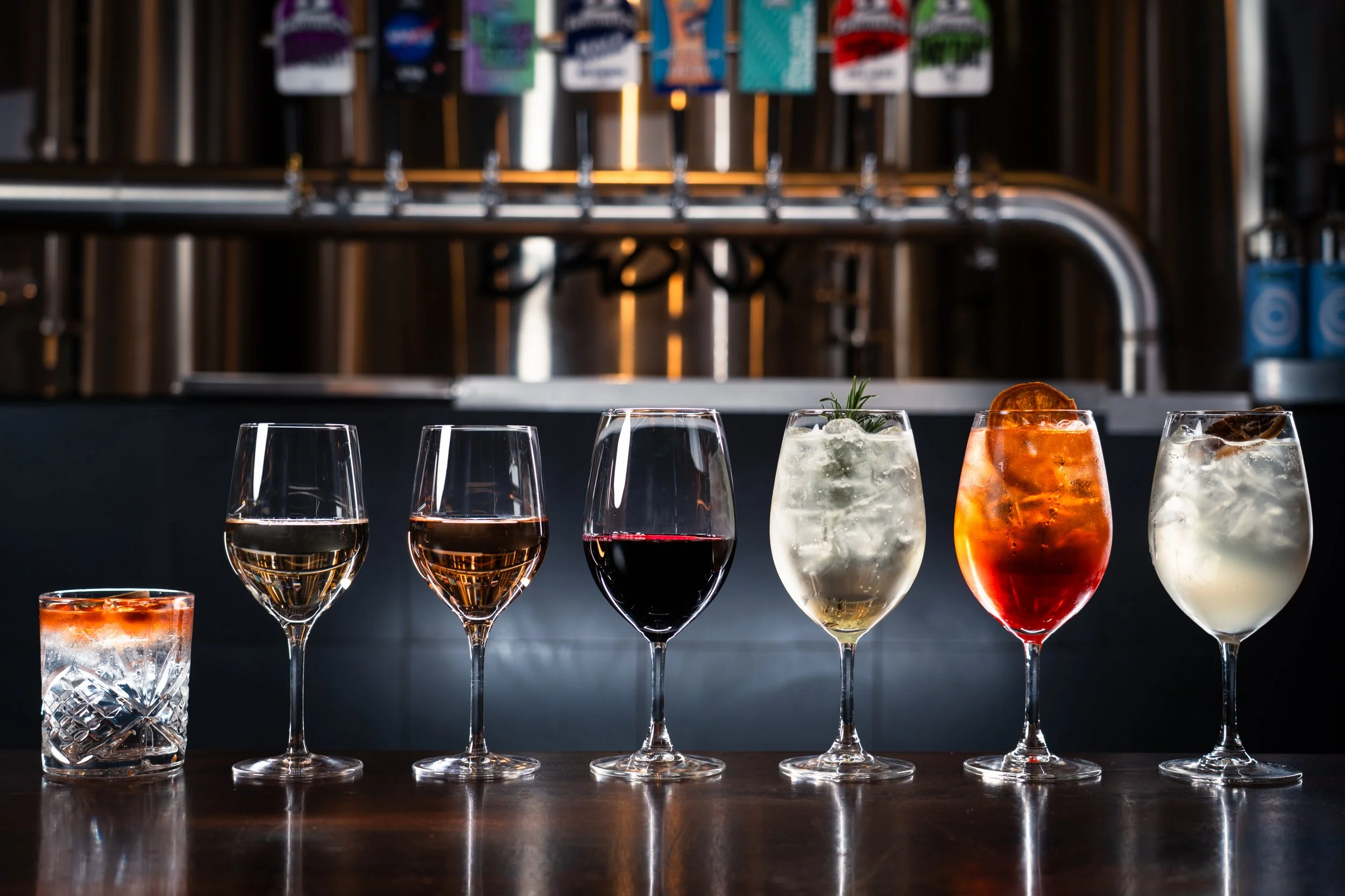 Assorted cocktails and wine glasses arranged in a row.