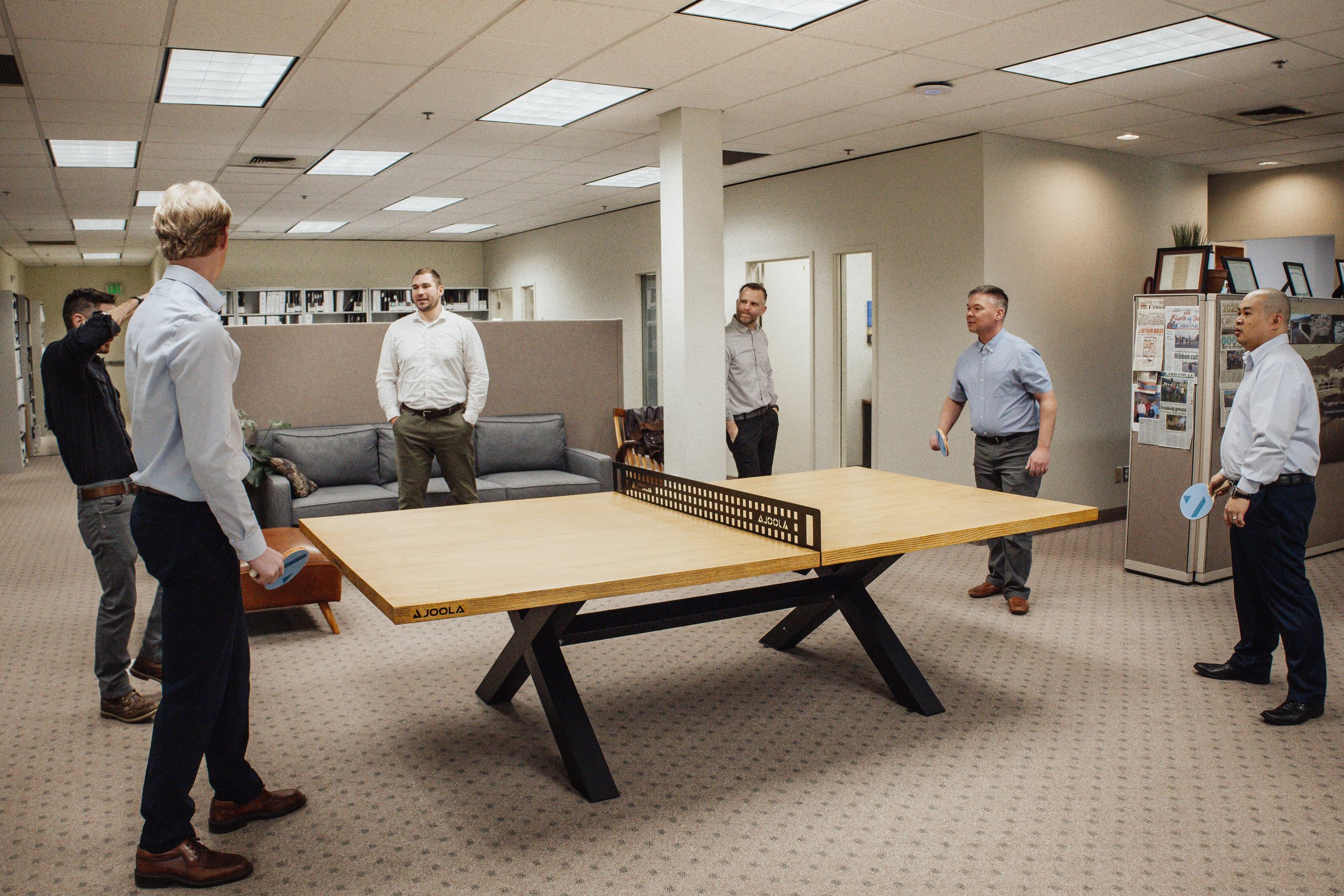 Six engineers at Varela Engineering & Management engage in company culture by playing ping pong in Spokane WA.