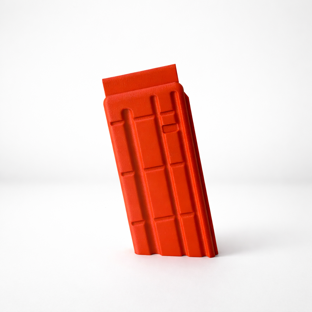 Red plastic climbing hold shaped like a rectangular block with grooves and ridges.