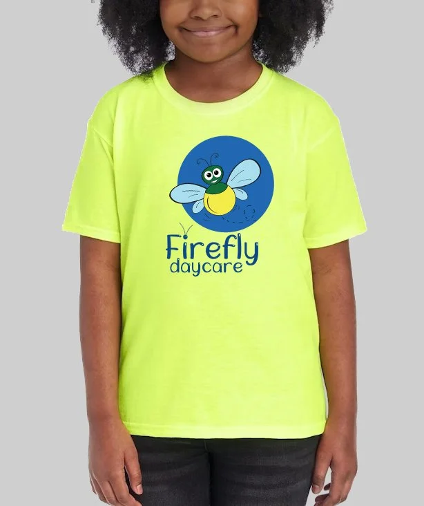 A girl wearing a bright yellow t-shirt with a cartoon fly and the words "Firefly daycare" on it.