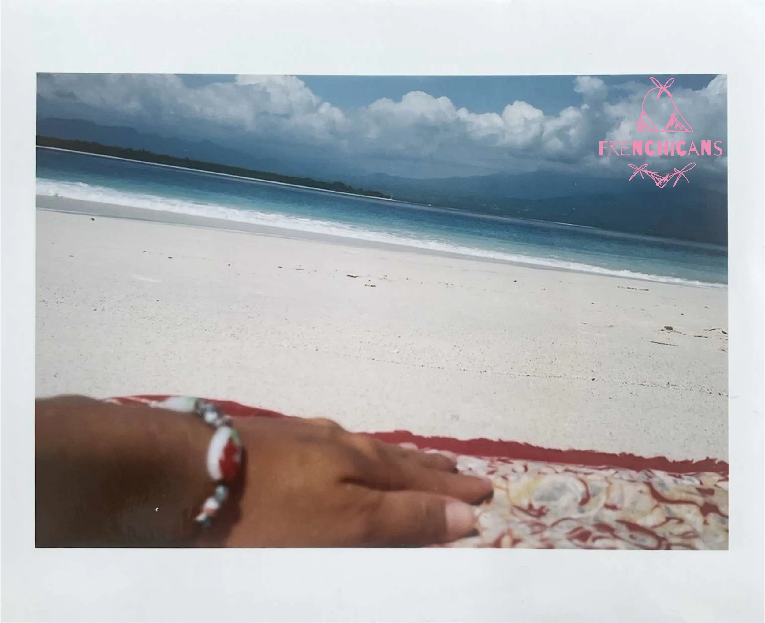 Beach scene with white sand, turquoise water, and cloudy sky.