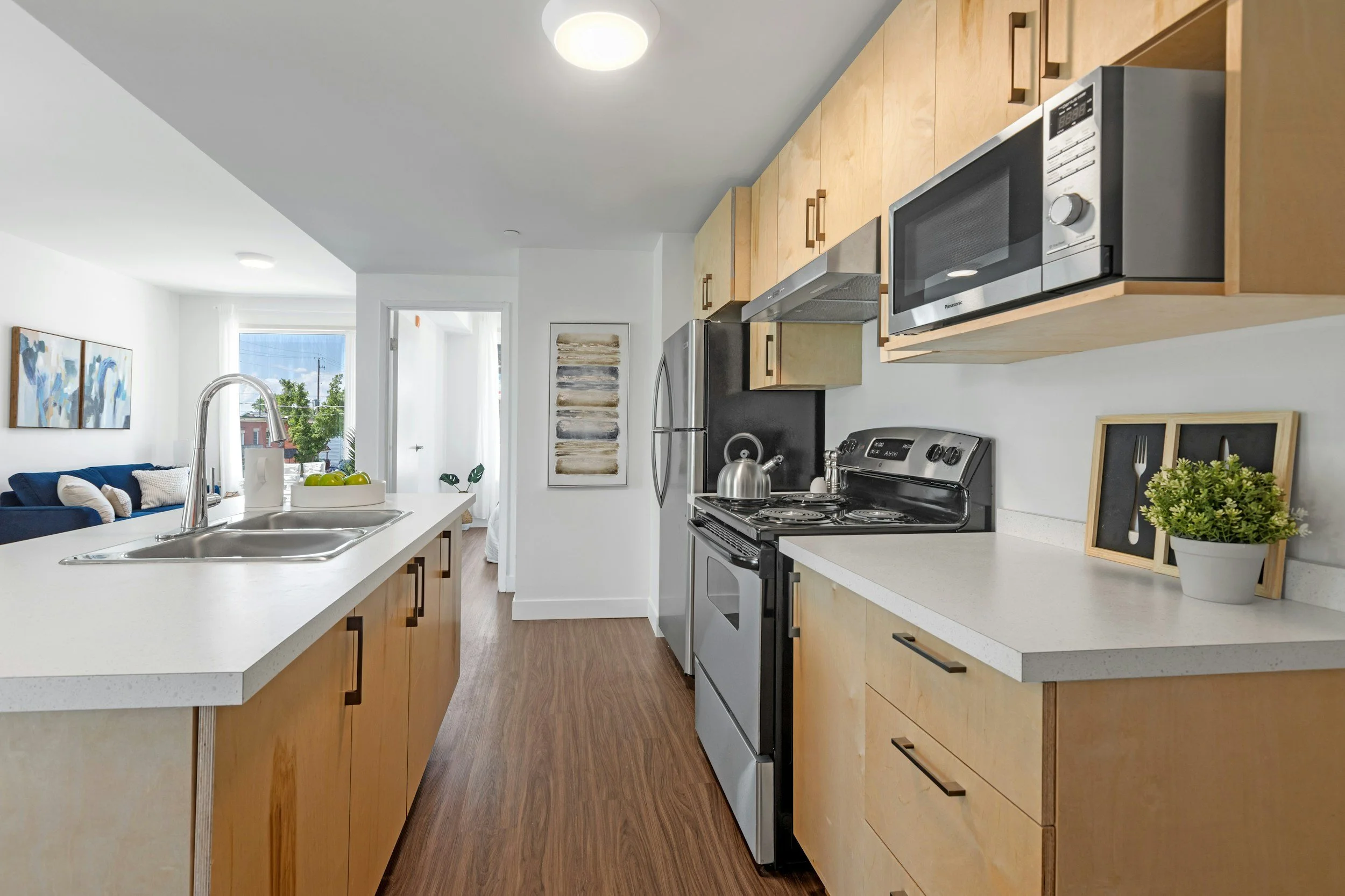Galley kitchen with natural wood cabinets and white countertops