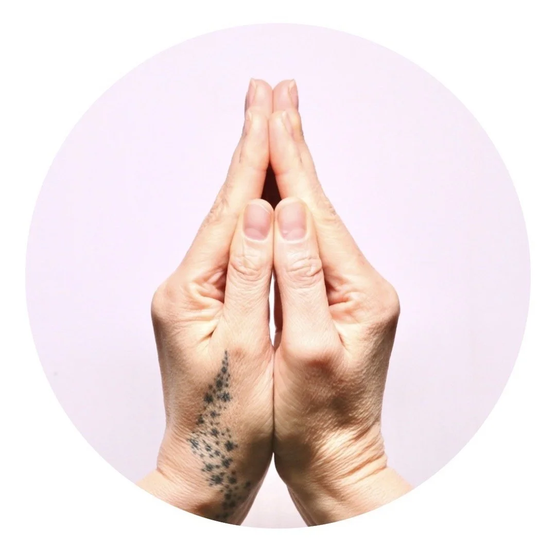 The Beloved mudra, to be in Soul's Light.Two hands in a prayer position against a light pink background.