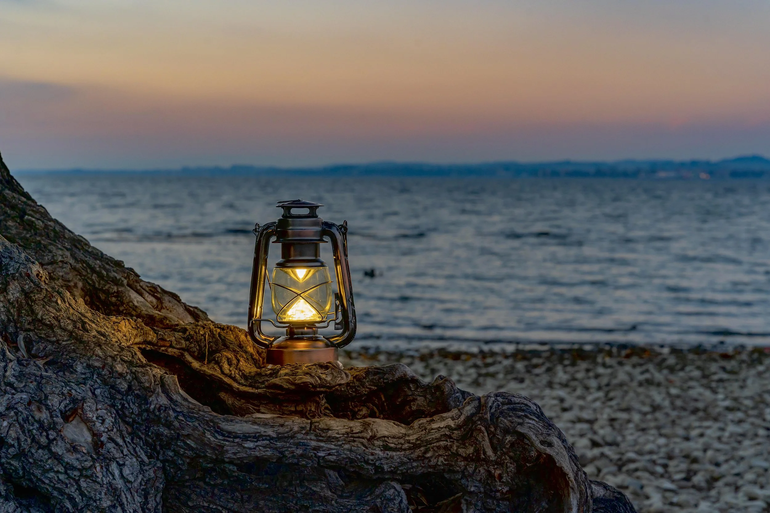 The lantern on the path, emitting warm light to guide.