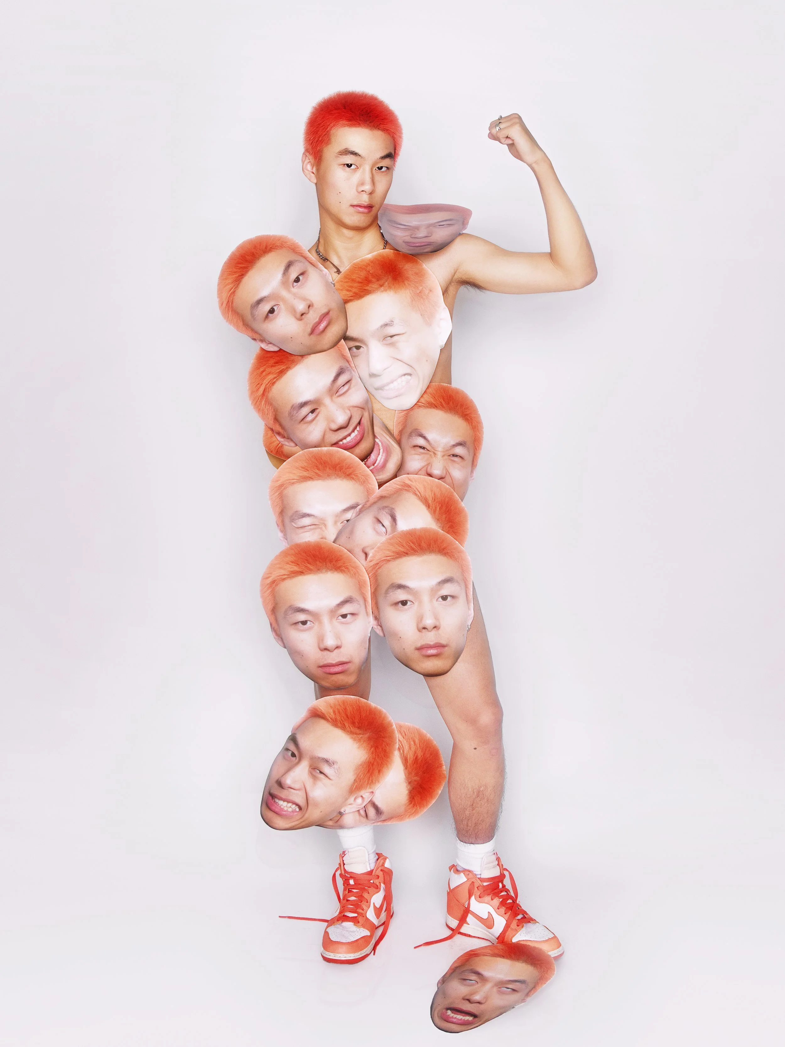 A person with orange hair and orange sneakers with white laces standing against a plain white background. Their body is covered with multiple overlapping images of their own face with various facial expressions and different orientations, creating a 