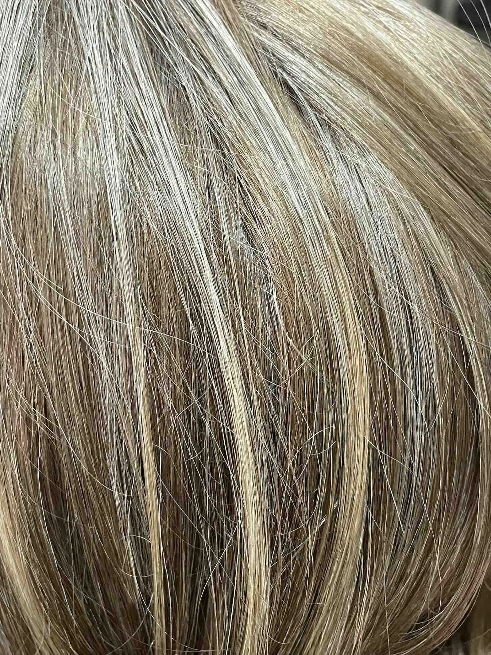 Close-up of blended gray hair with natural dimension — gray blending by Albert Narcisse, Master Hair Colorist NYC