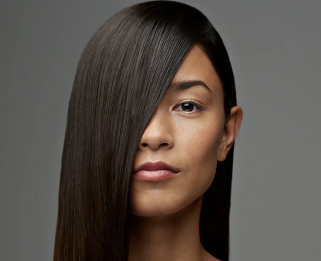 Sleek, smooth dark hair with a refined finish after a keratin smoothing treatment, showing natural shine, control, and soft movement.