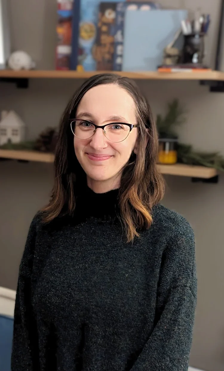 Blake Bender, licensed marriage & family therapist at Resourced & Resilient, smiling in a warm therapy office setting. Click here for Blake Bender's bio.