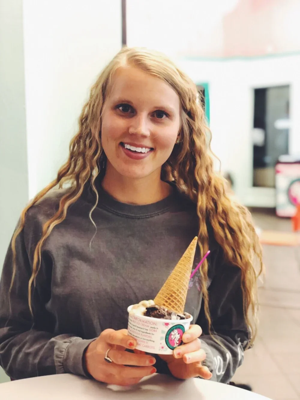 Jenni Burg, registered dietitian at Resourced & Resilient, smiling and holding a cup of ice cream. Click here for Jenni Burg's bio.