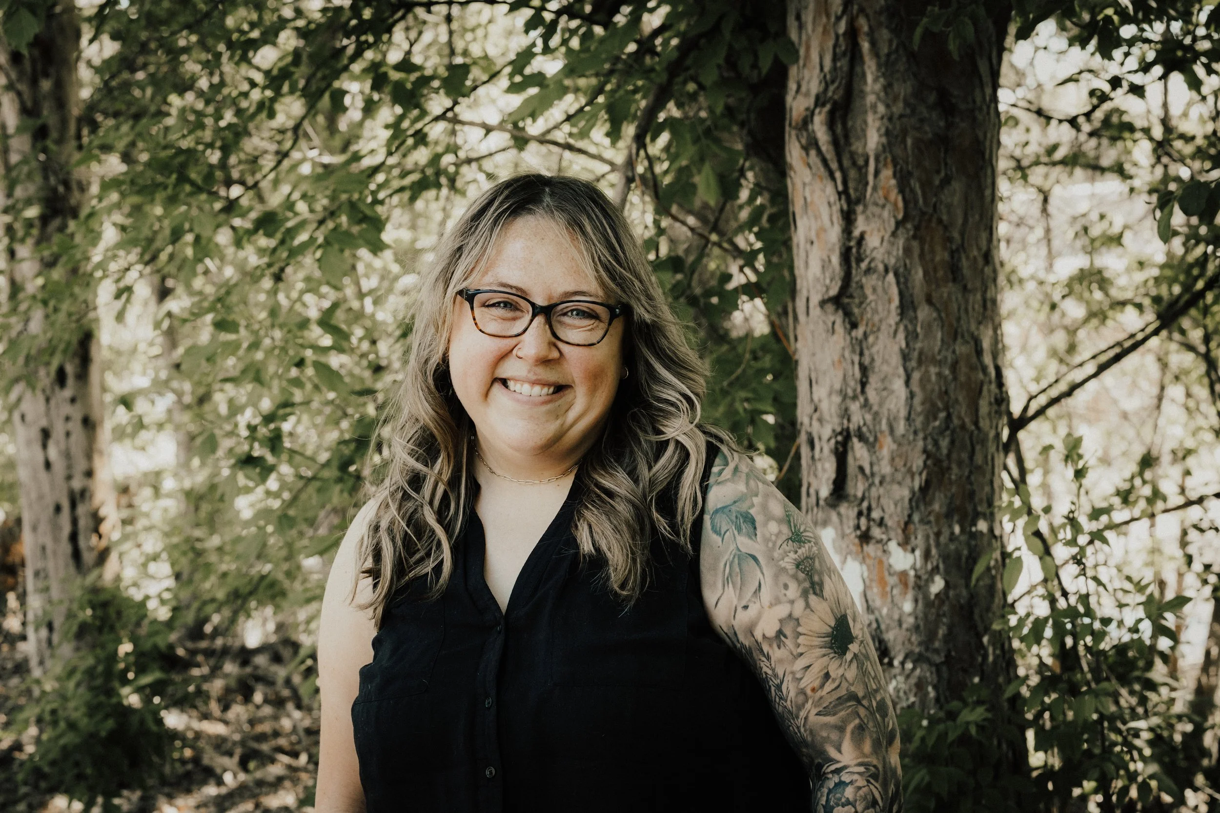 Hannah Blaha, licensed professional clinical counselor and COO at Resourced & Resilient, smiling in an outdoor portrait with a dog. Click here for Hannah Blaha's bio.