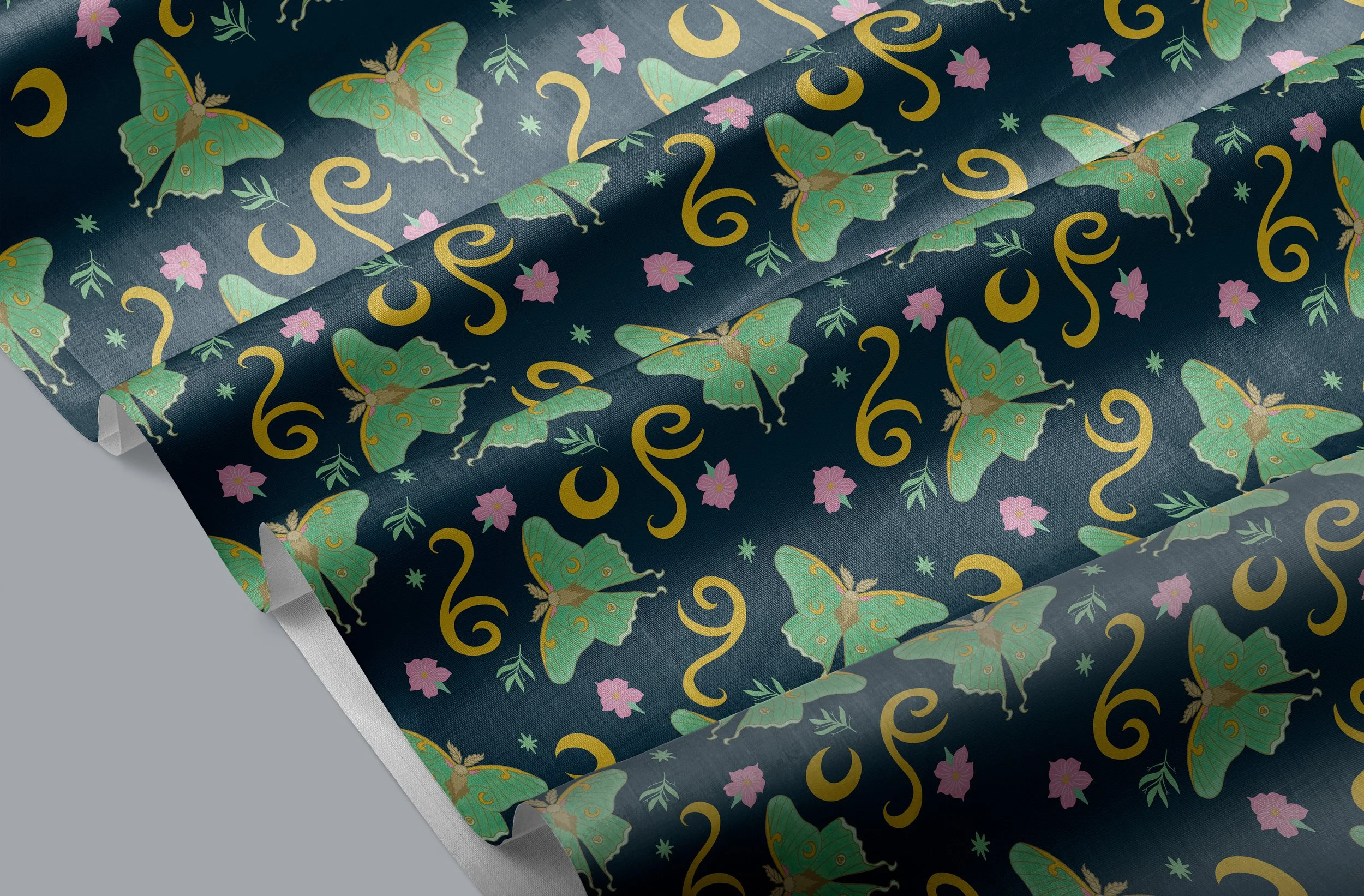 Close-up of wrapping paper with a butterfly and floral pattern in green, pink, and gold on a dark blue background.