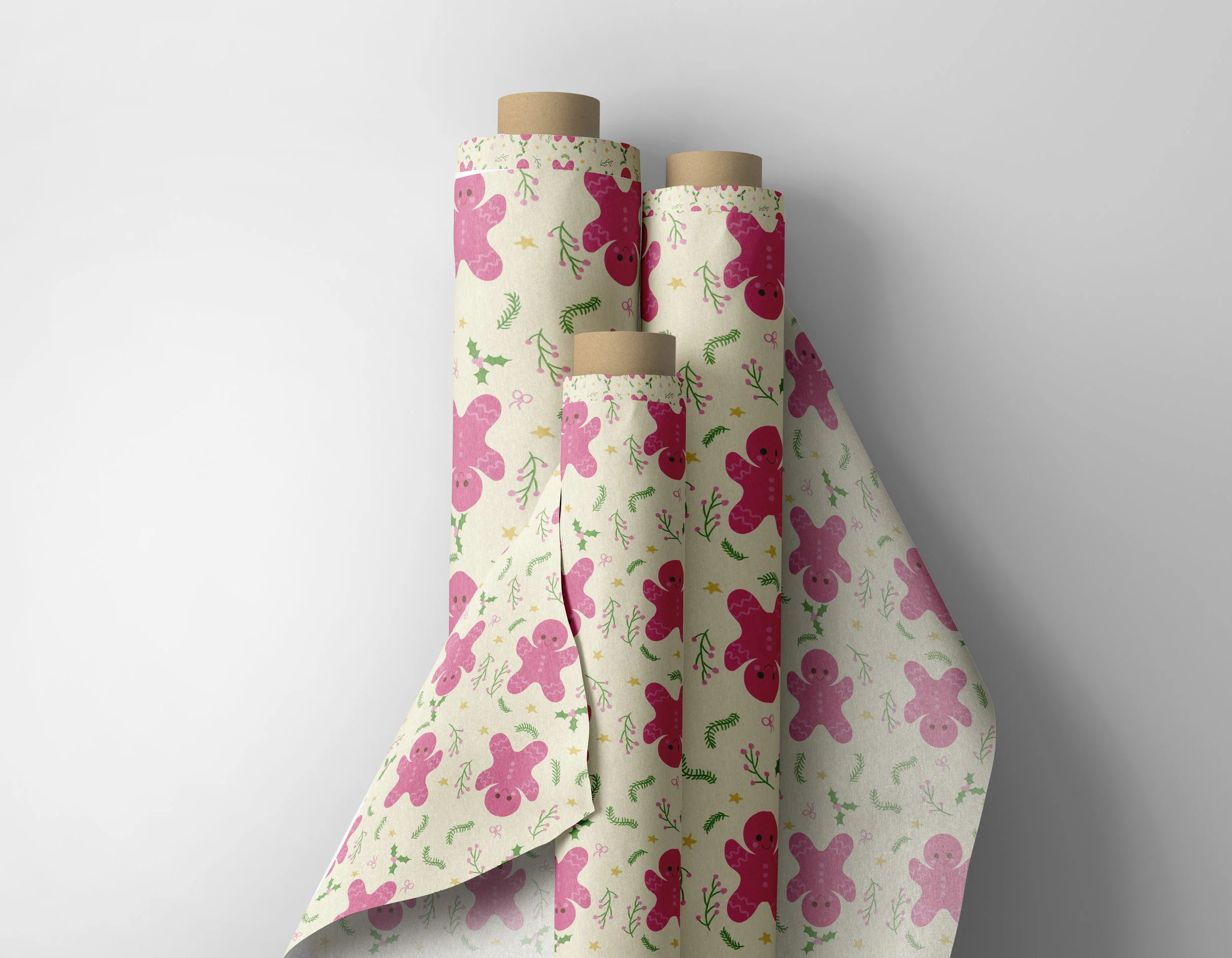 Three rolls of wrapping paper with a gingerbread man pattern, on a white background.