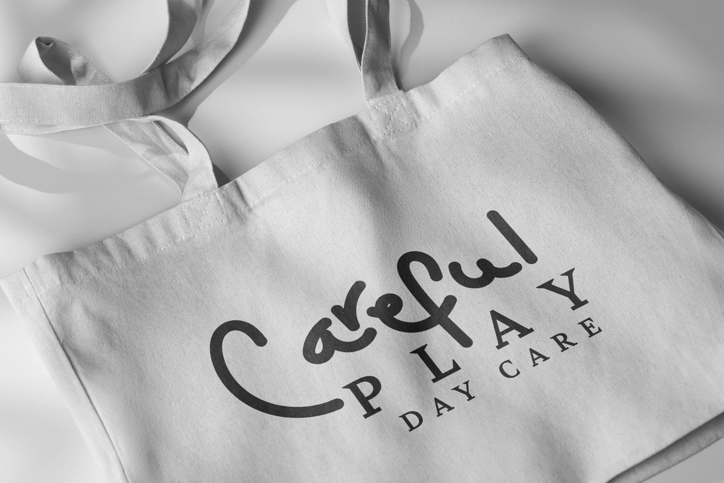 A white fabric bag with the words 'Cared for with Love Days of Care' printed on it in black.