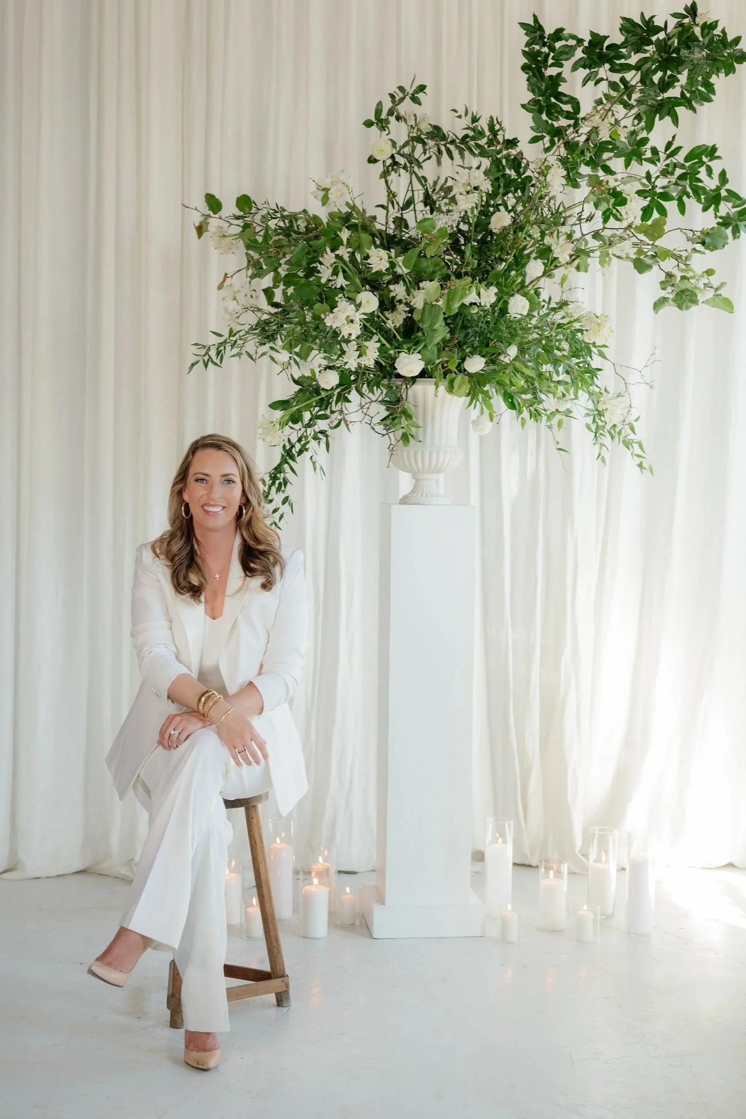 Luxury wedding planner Handley Breaux seated in a refined studio setting, embodying the elevated style, intentional hospitality, and attention to detail that define Handley Breaux Designs.