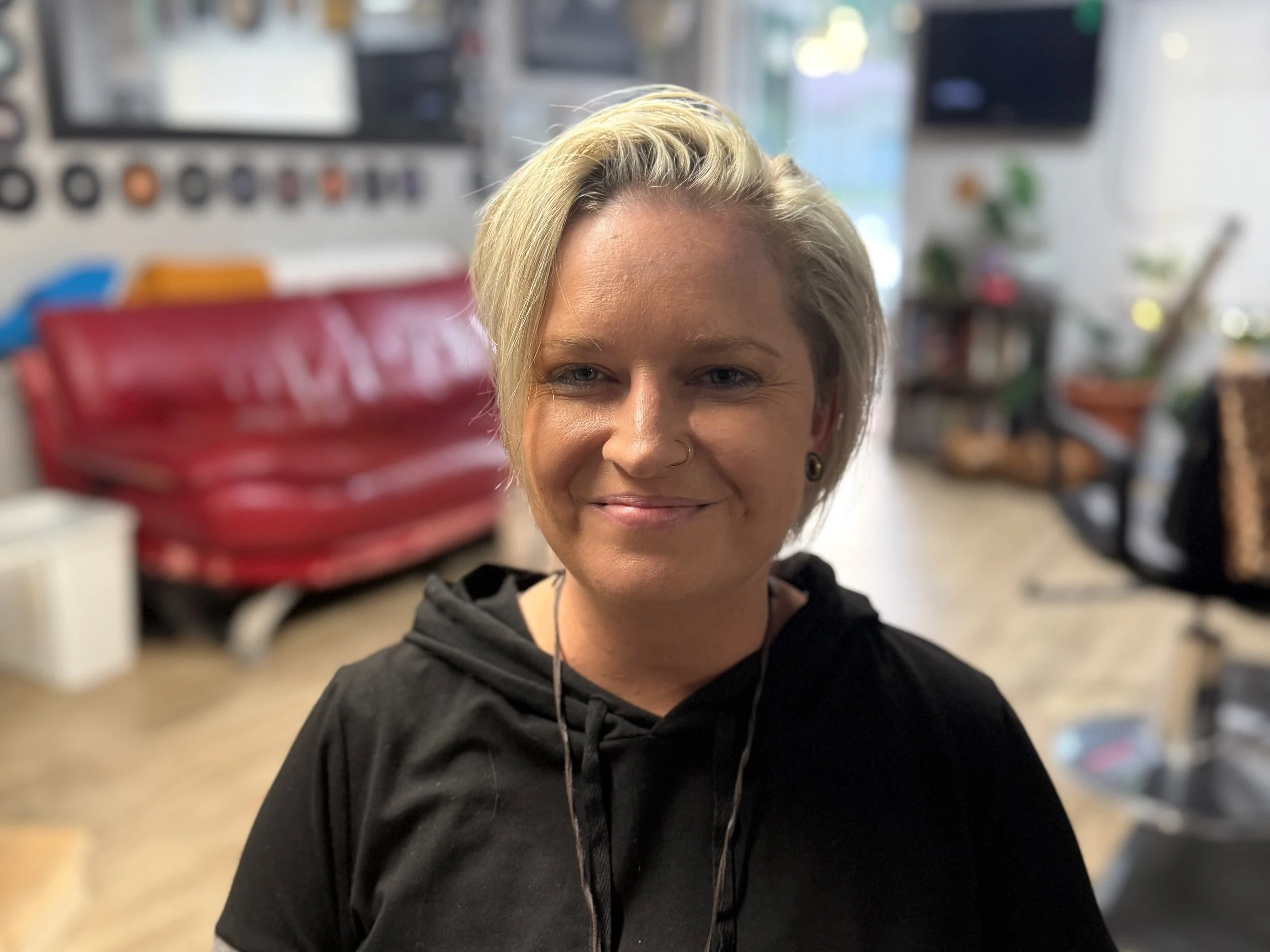Smiling client after gender neutral short haircut at inclusive hair salon in New Port Richey