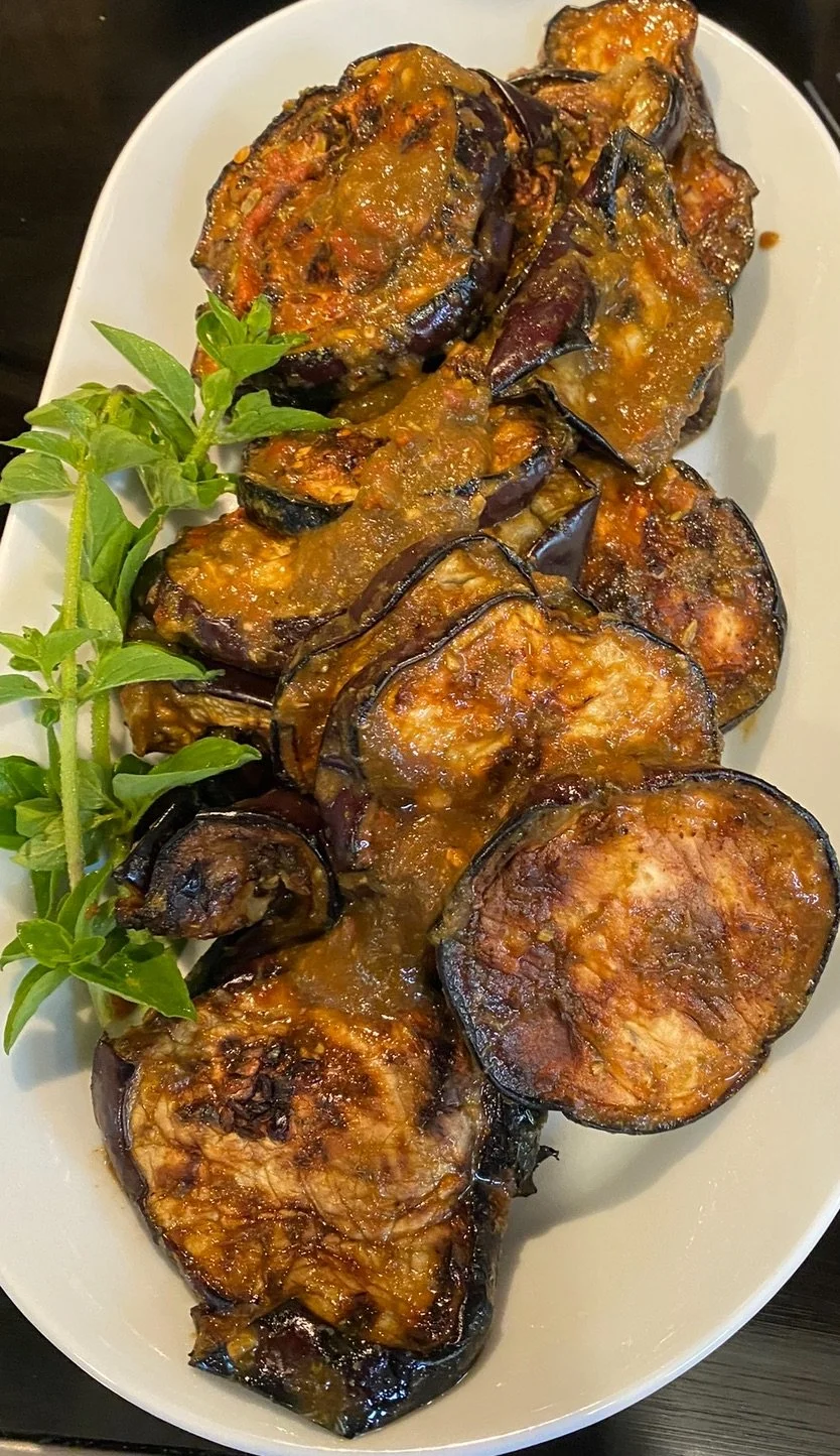 Plate of eggplant parmesan garnished with fresh basil leaves.