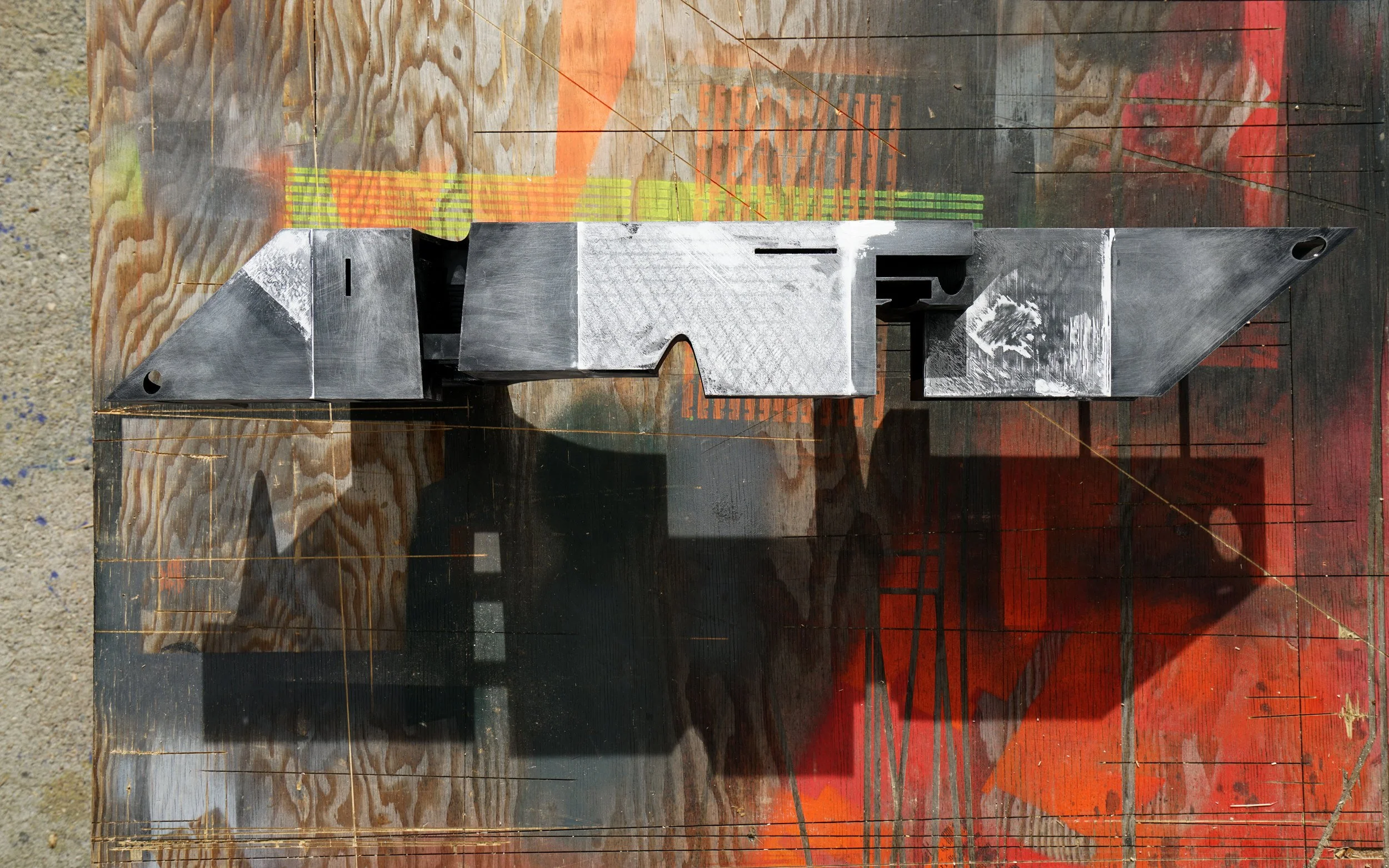 Overhead view of an architectural model in construction piece on a colorful workbench.