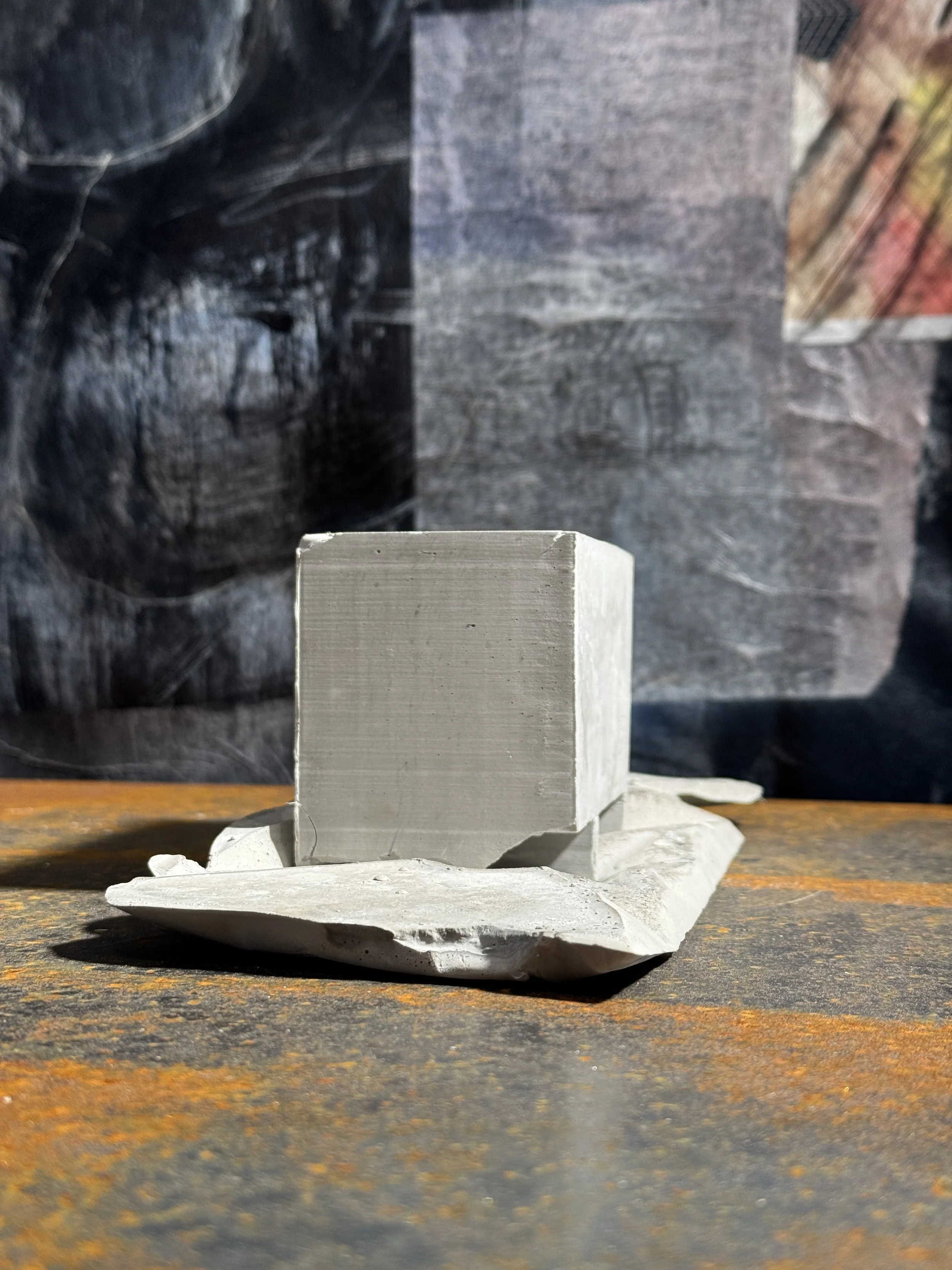 A small concrete sculpture on a corten steel base