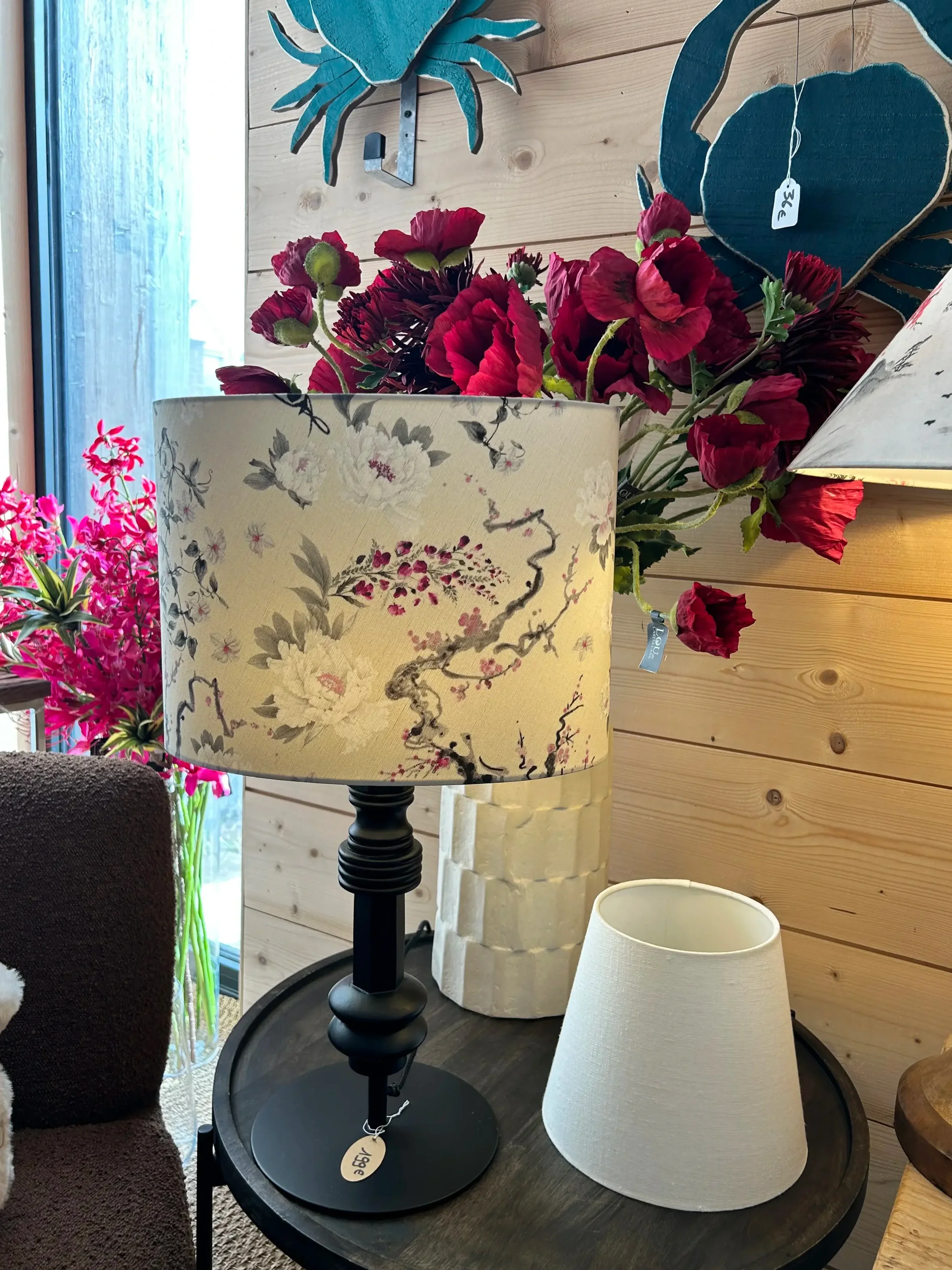 Lampes de table avec abat-jour décoratif, décor floral, dans un intérieur avec murs en bois et fleurs artificielles