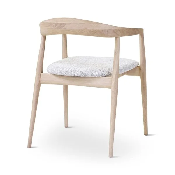 Chaise en bois clair avec coussin gris sur le siège.
