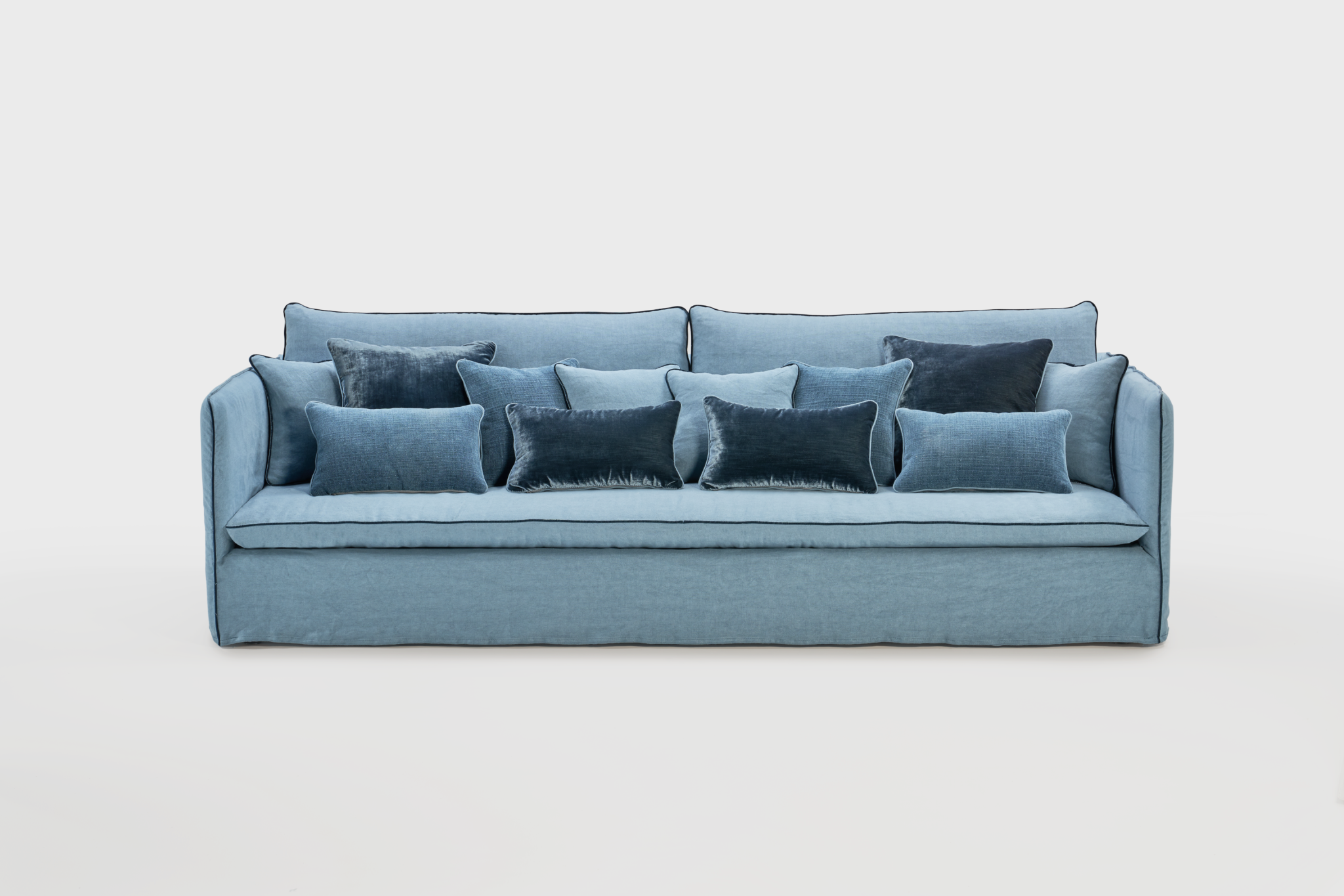 Canapé bleu avec plusieurs coussins dans différentes teintes de bleu.
