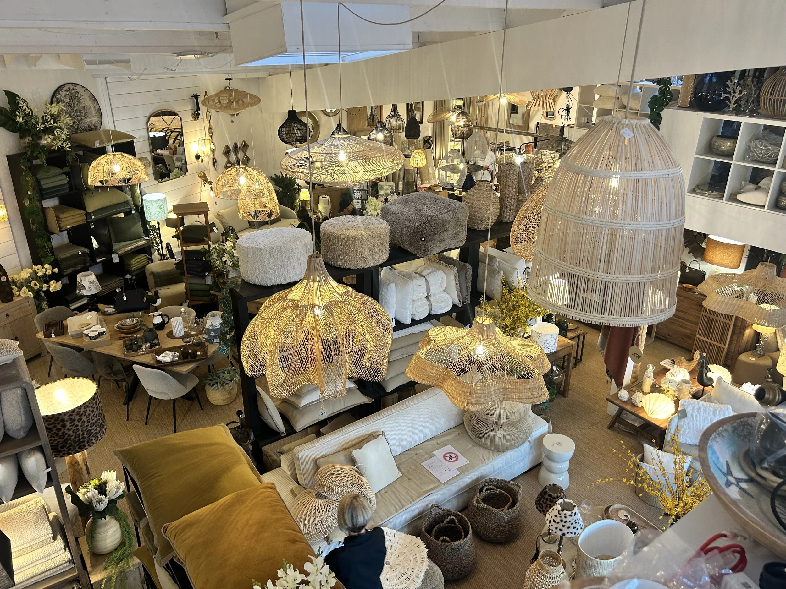Une boutique d'ameublement avec un grand choix de luminaires en rotin ou en osier, des meubles et des décorations de style naturel et cosy.