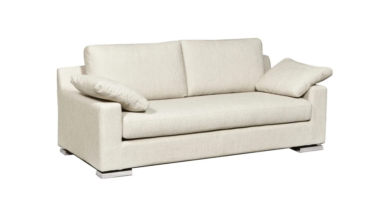 Canapé beige avec deux coussins, en cuir ou tissu, sur un fond blanc