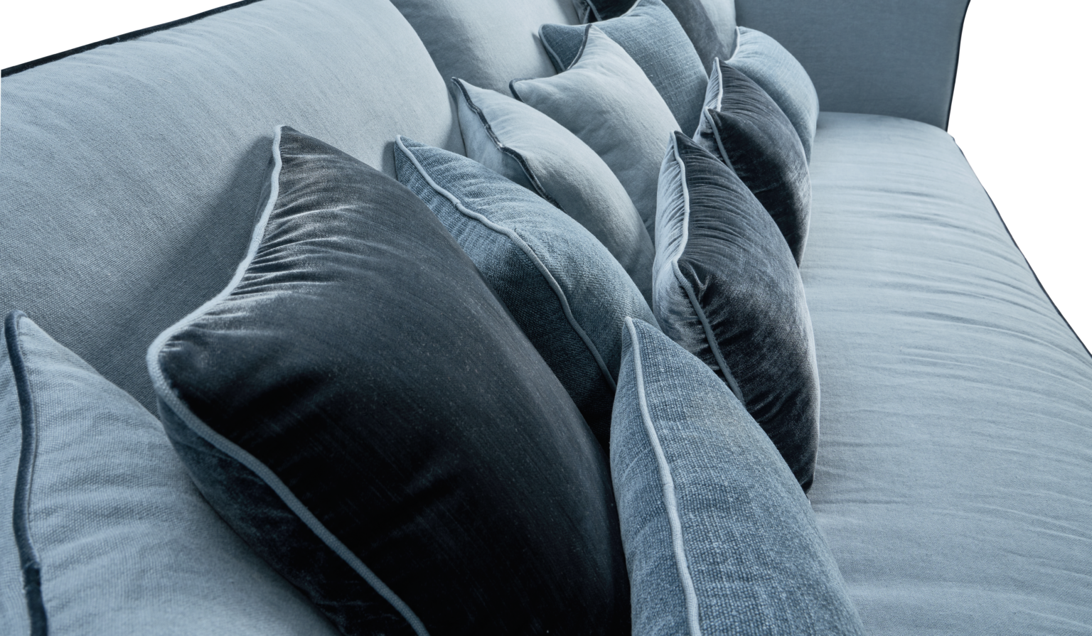 Coussins en velours gris et noir disposés sur un canapé en tissu gris clair.