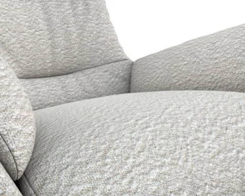 Coussin gris en tissu sur un canapé.